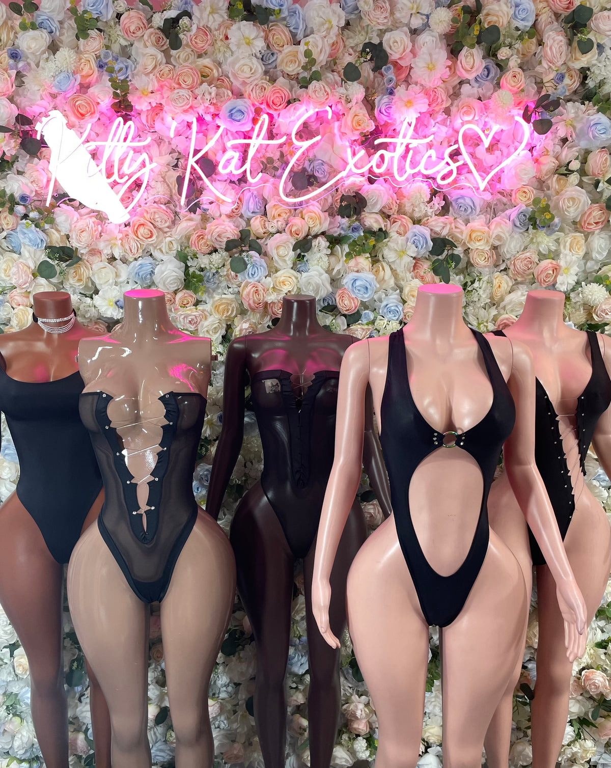 Black scoop-neck one-piece bodysuits on mannequins, high-leg cut