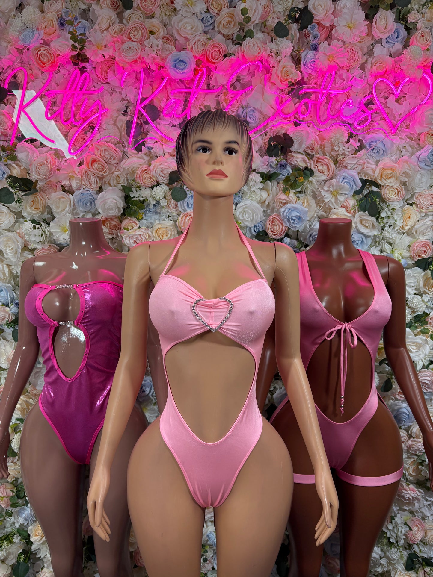 Metallic pink one-piece rave bodysuit with bow-tie neckline and heart keyhole