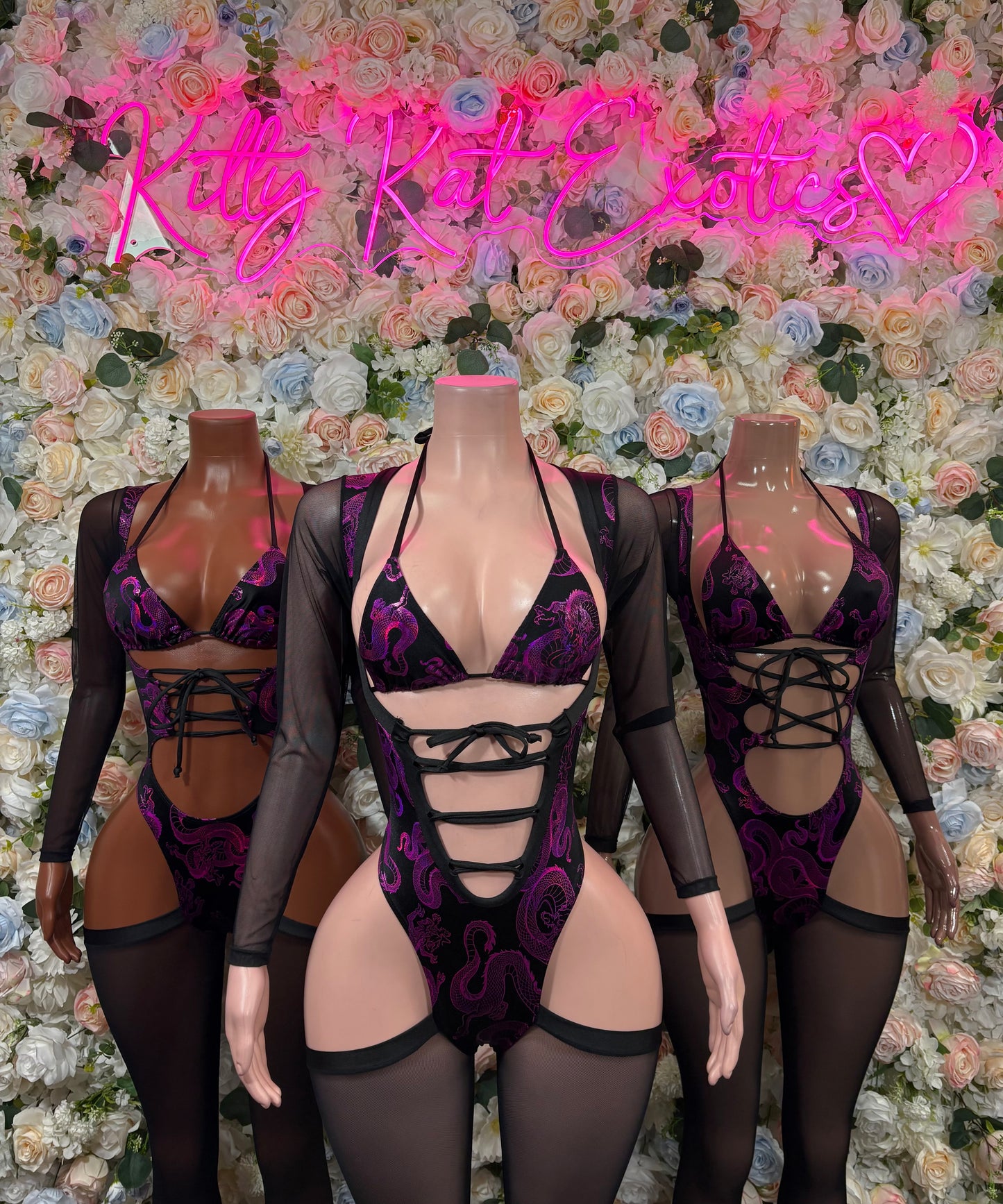 Purple lace bodysuit with black mesh sleeves, lace-up front cutouts, strappy garters