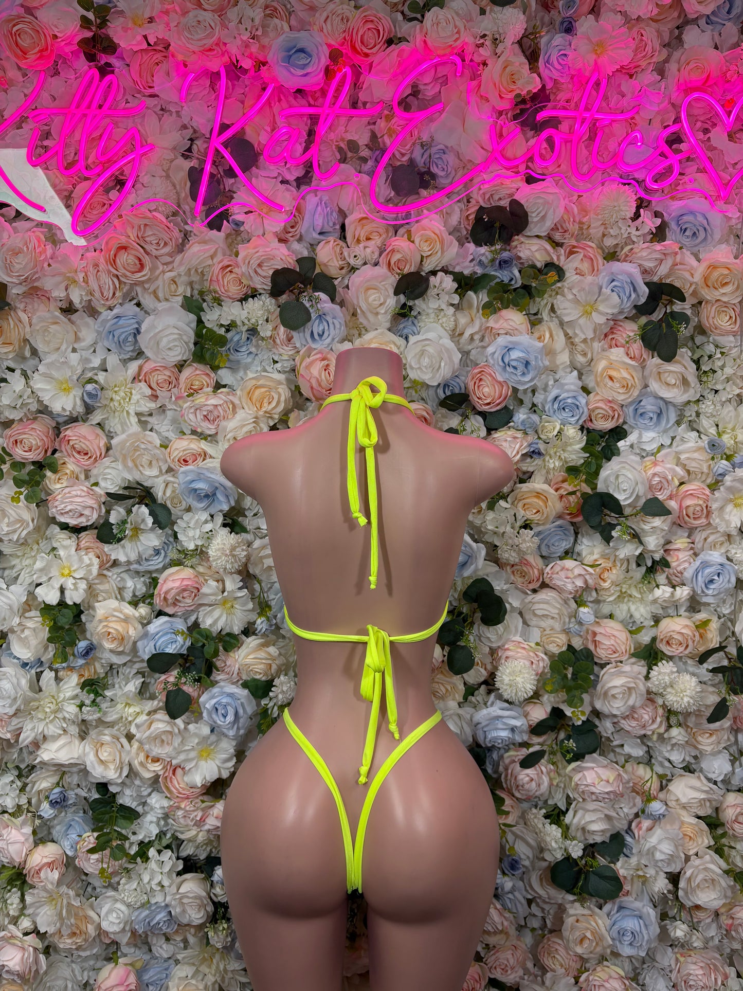 Back view: neon green two-piece bikini set with black mesh string straps and tied thong