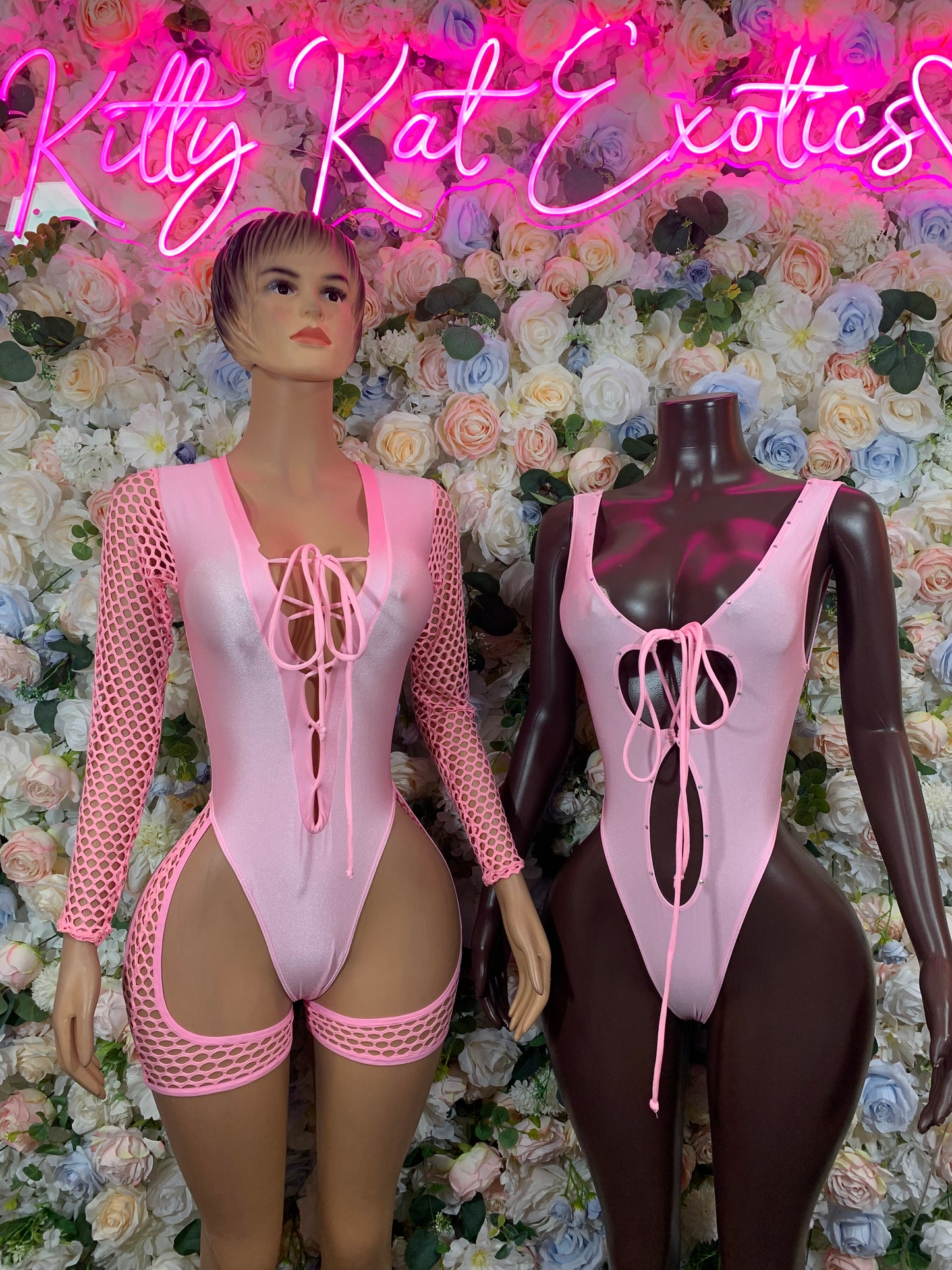 Pink one-piece bodysuit with lace-up front, sheer mesh long sleeves and garter cutouts