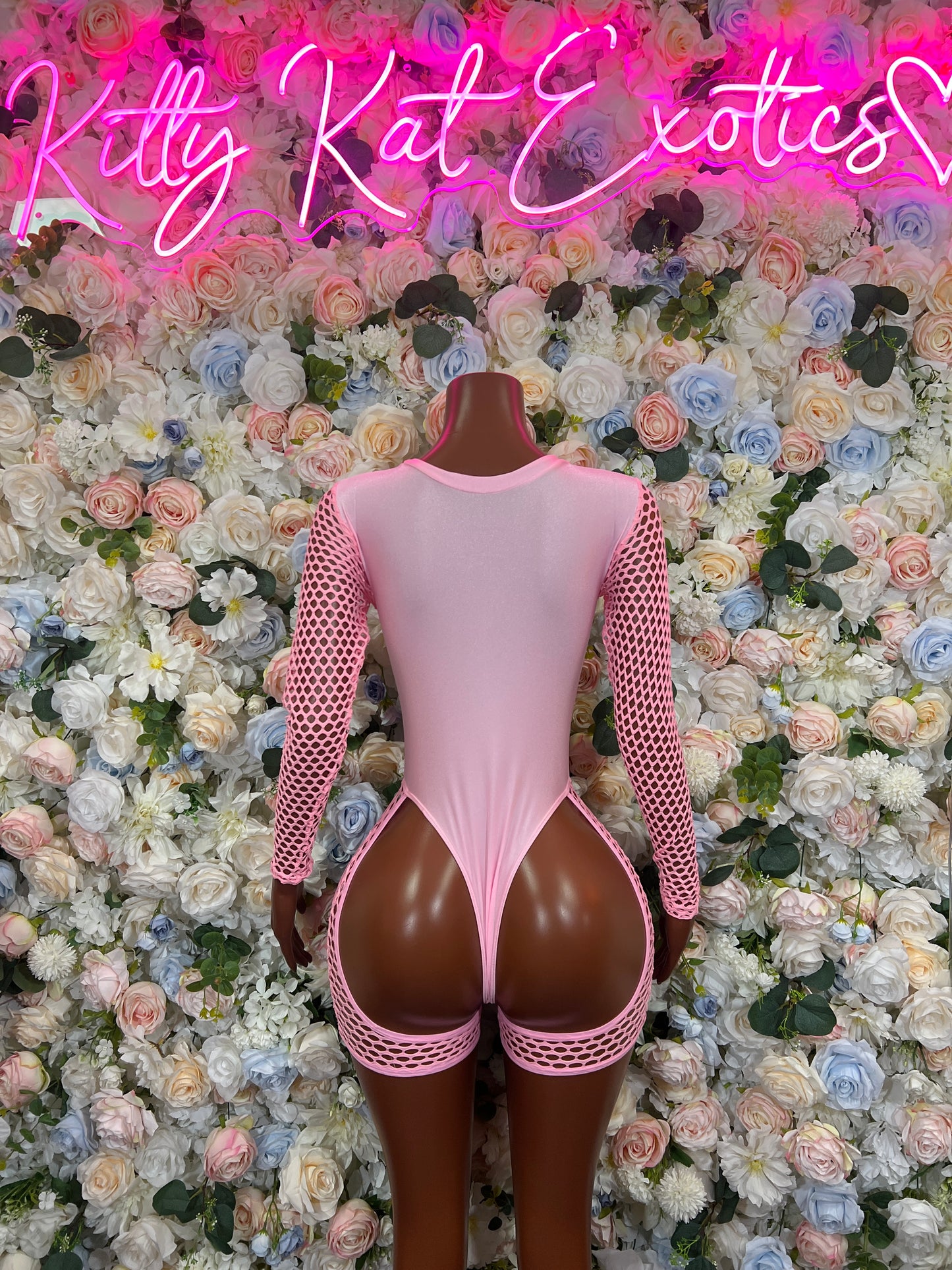 Pink bodysuit with fishnet sleeves and high-cut backless design, scalloped hem trim