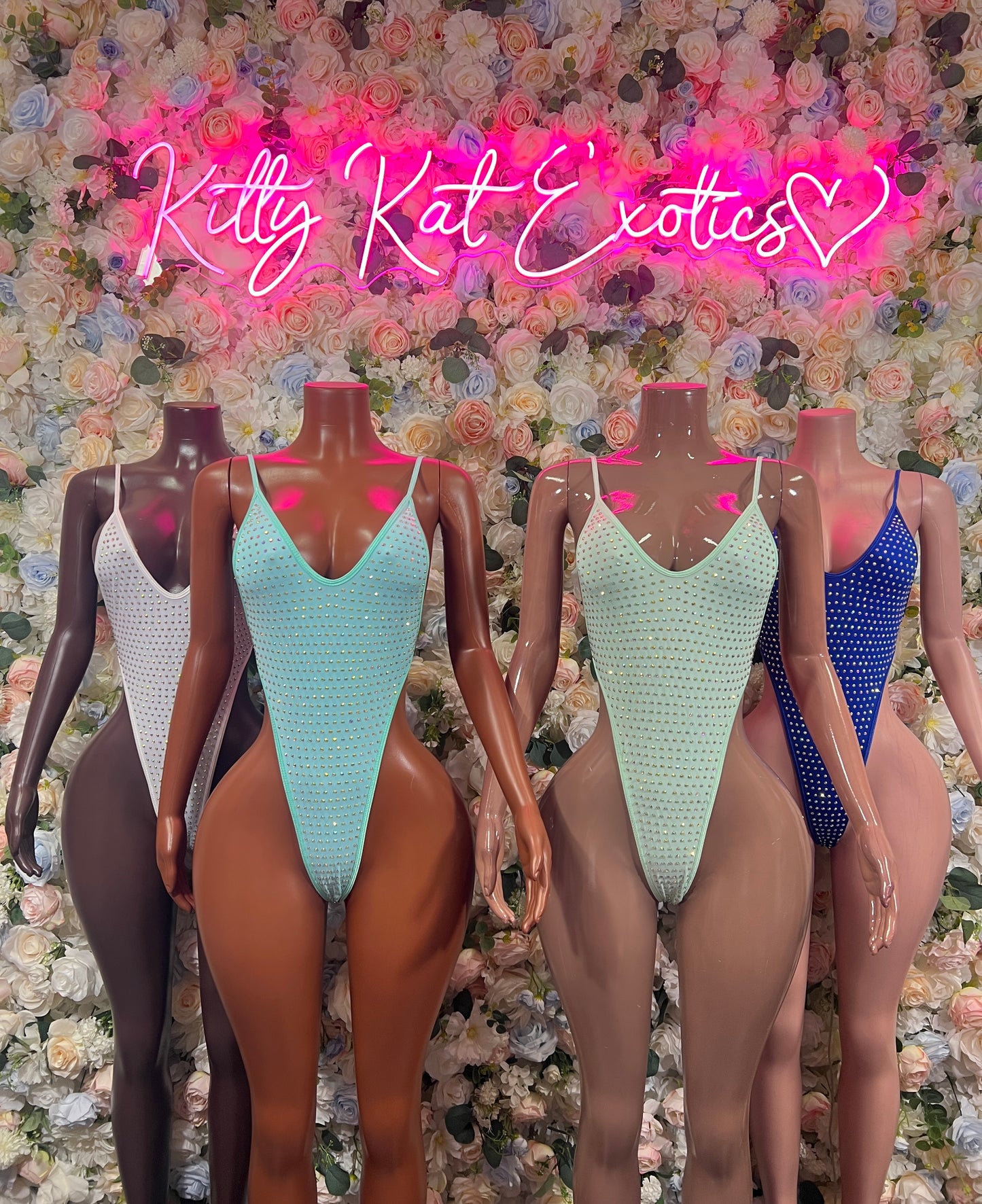 Turquoise rhinestone bodysuit with V-neck and thin straps on a mannequin