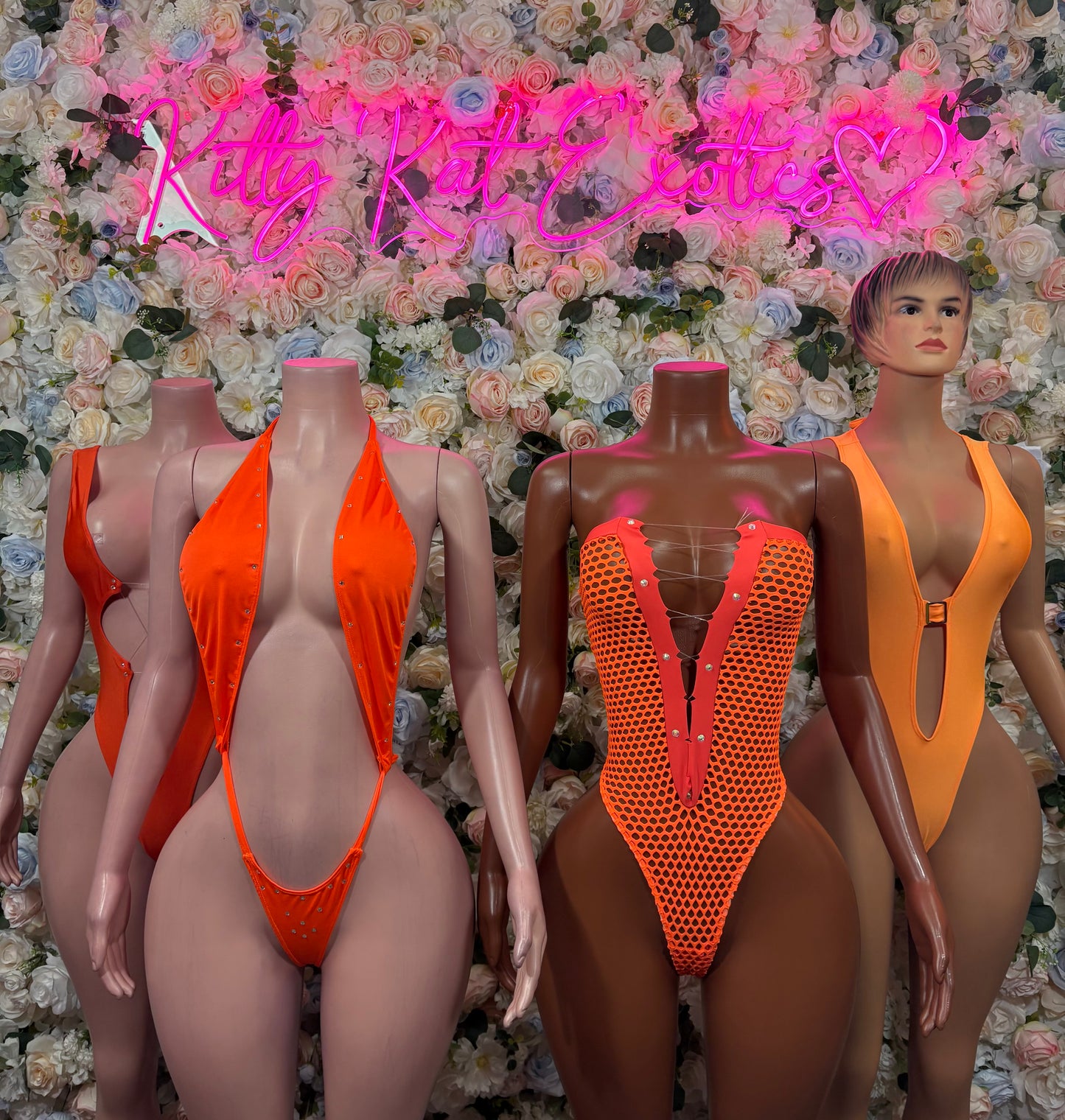Orange bodysuit display on mannequins: solid V-neck front and red mesh panel bodysuit