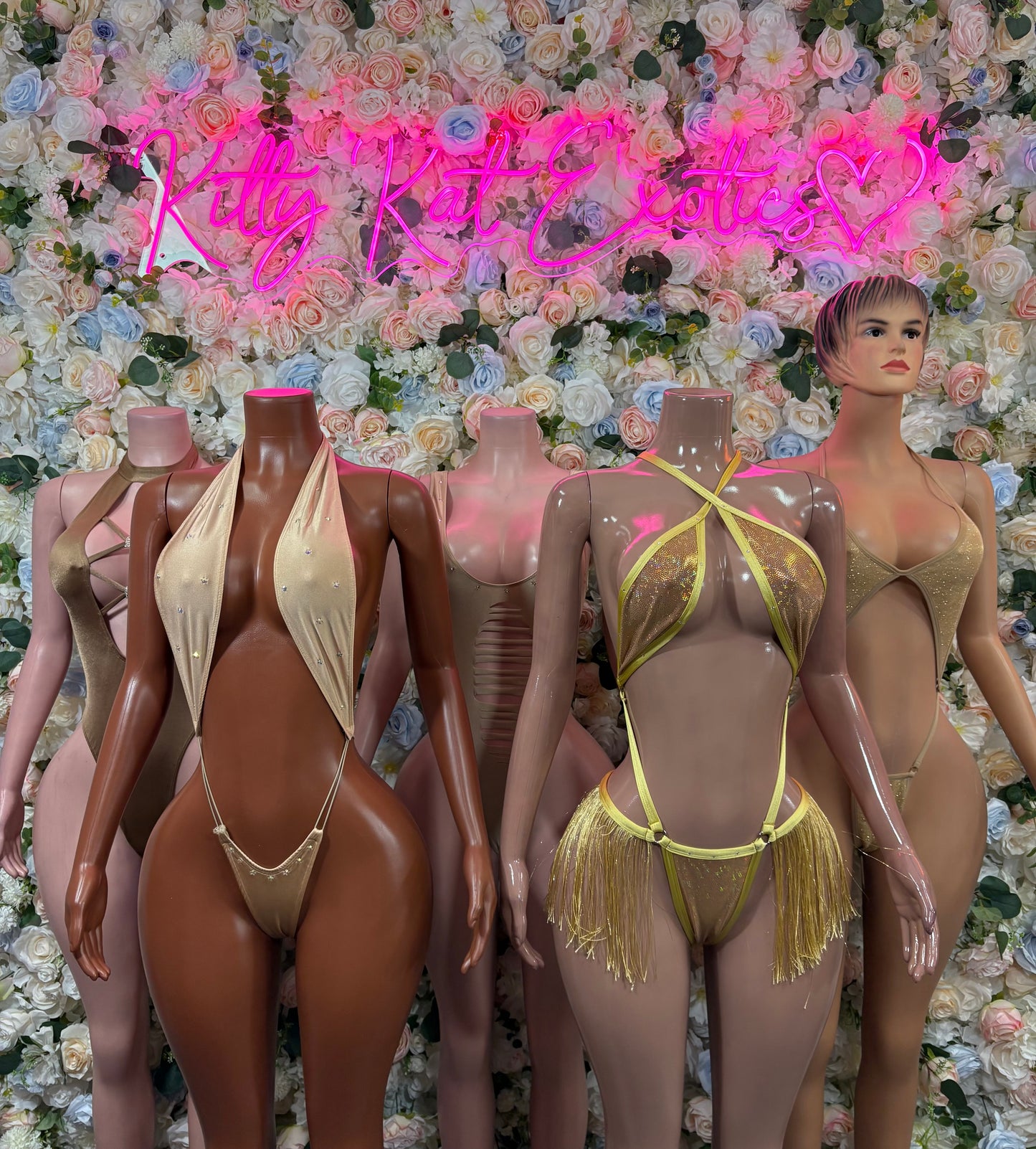 Tan one-piece bodysuits on mannequins, low V neckline and high-cut legs