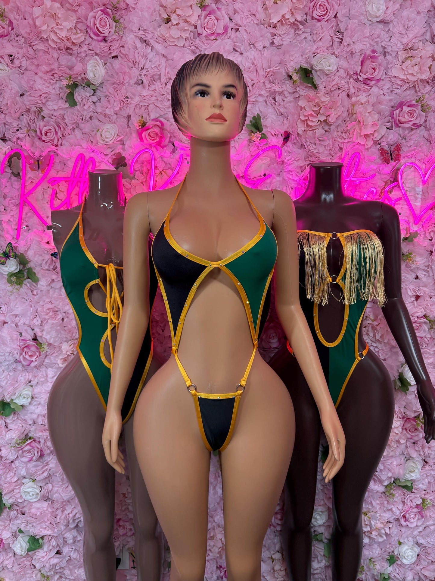 Jamaica flag bodysuit on model, black one-piece with yellow and green strap accents