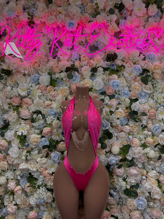 Pink one-piece bodysuit with deep V neckline, chain straps, and high-cut leg