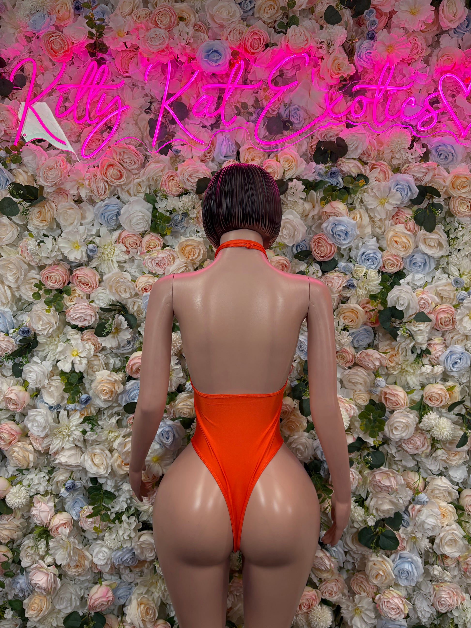 Orange halter one-piece bodysuit, back view with cutout details
