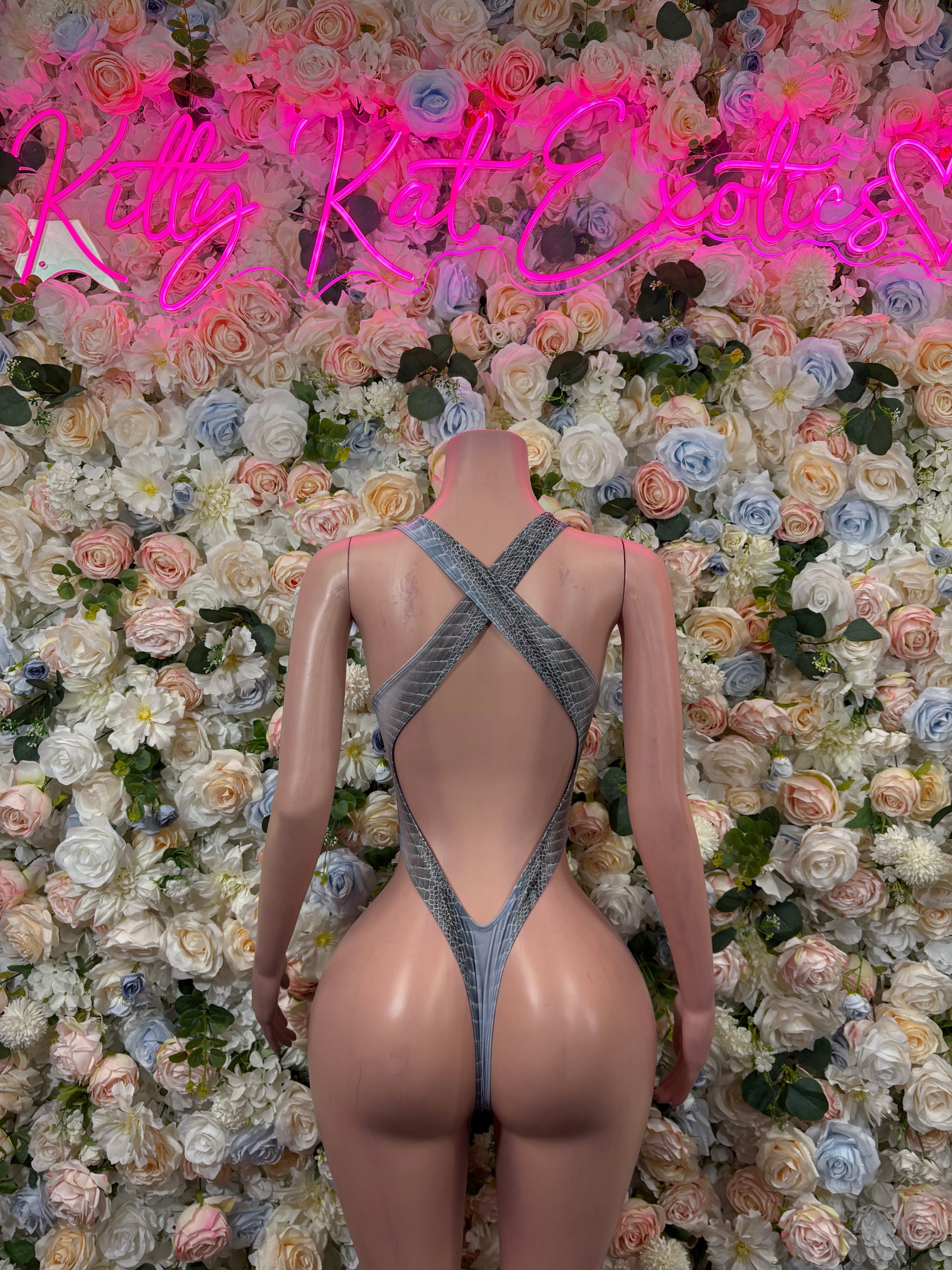 Snake-print bodysuit with crisscross straps on back and high-cut leg