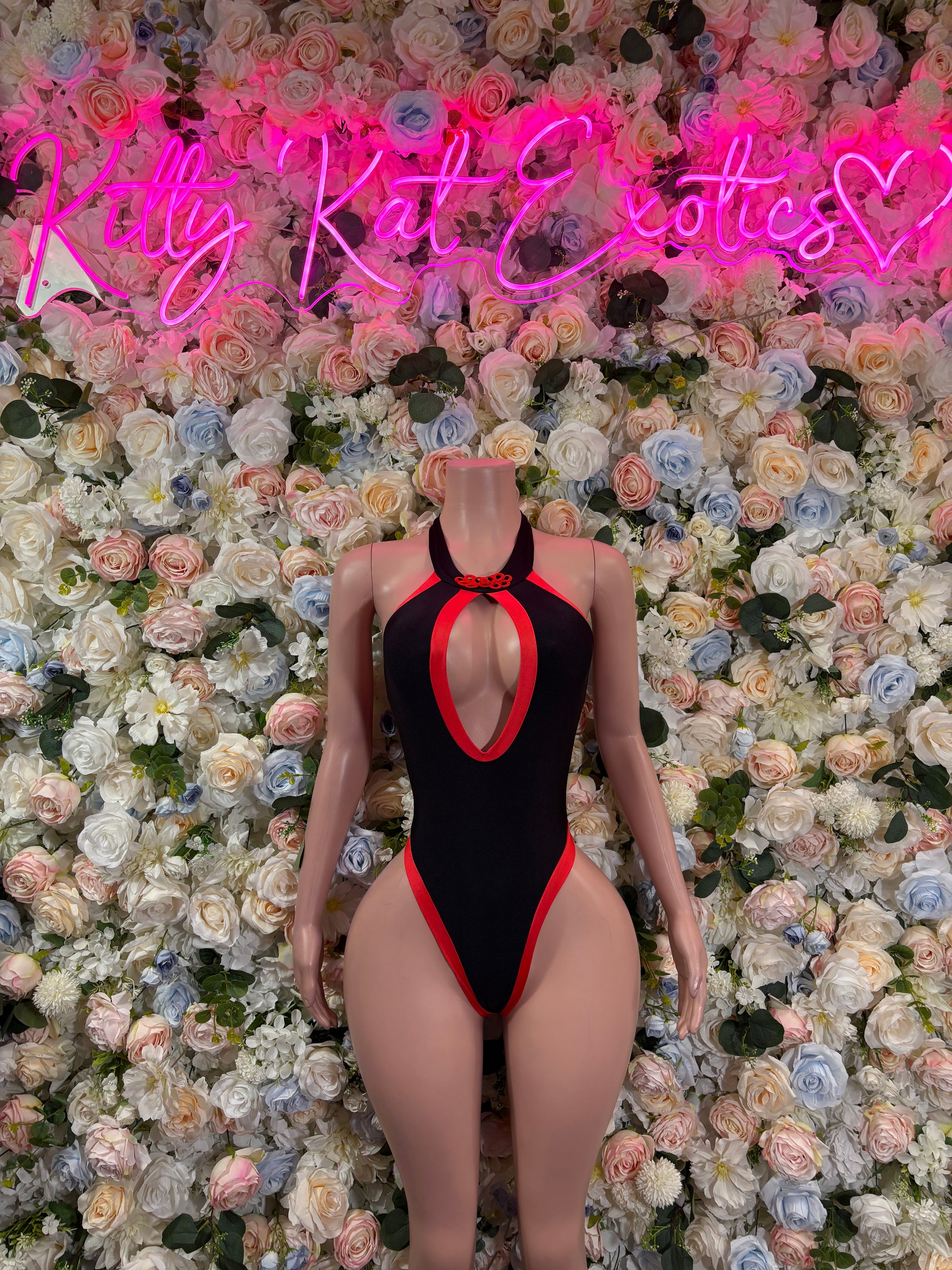 Black one-piece bodysuit with red trim and oval back keyhole cutout.