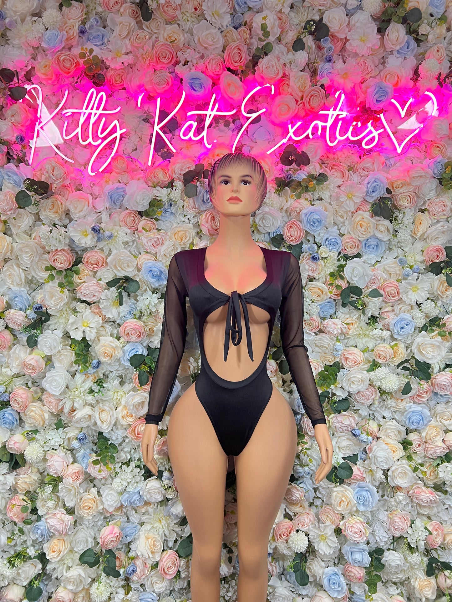 Black one-piece bodysuit with long sleeves, deep V neckline, and center tie detail