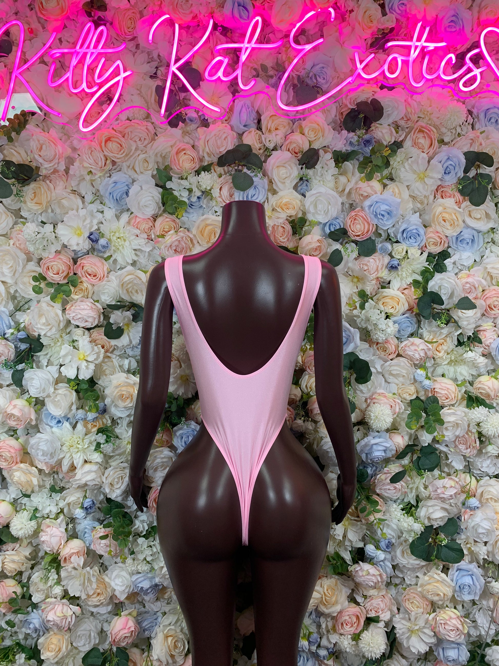 Baby pink one-piece bodysuit with deep V back and thin lace-up ties at center