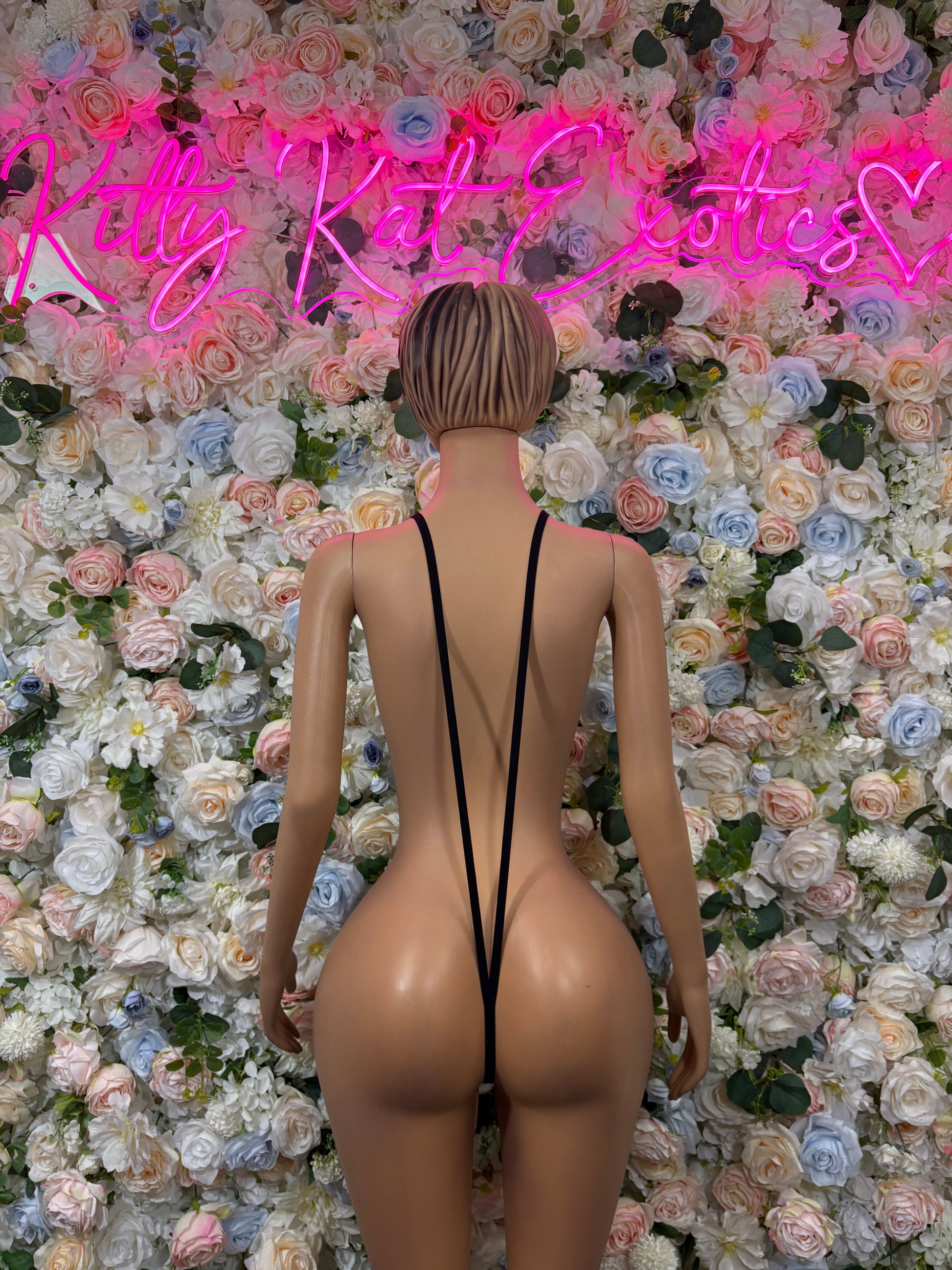 Gold sequin slingshot bodysuit with open back and black straps, back view.