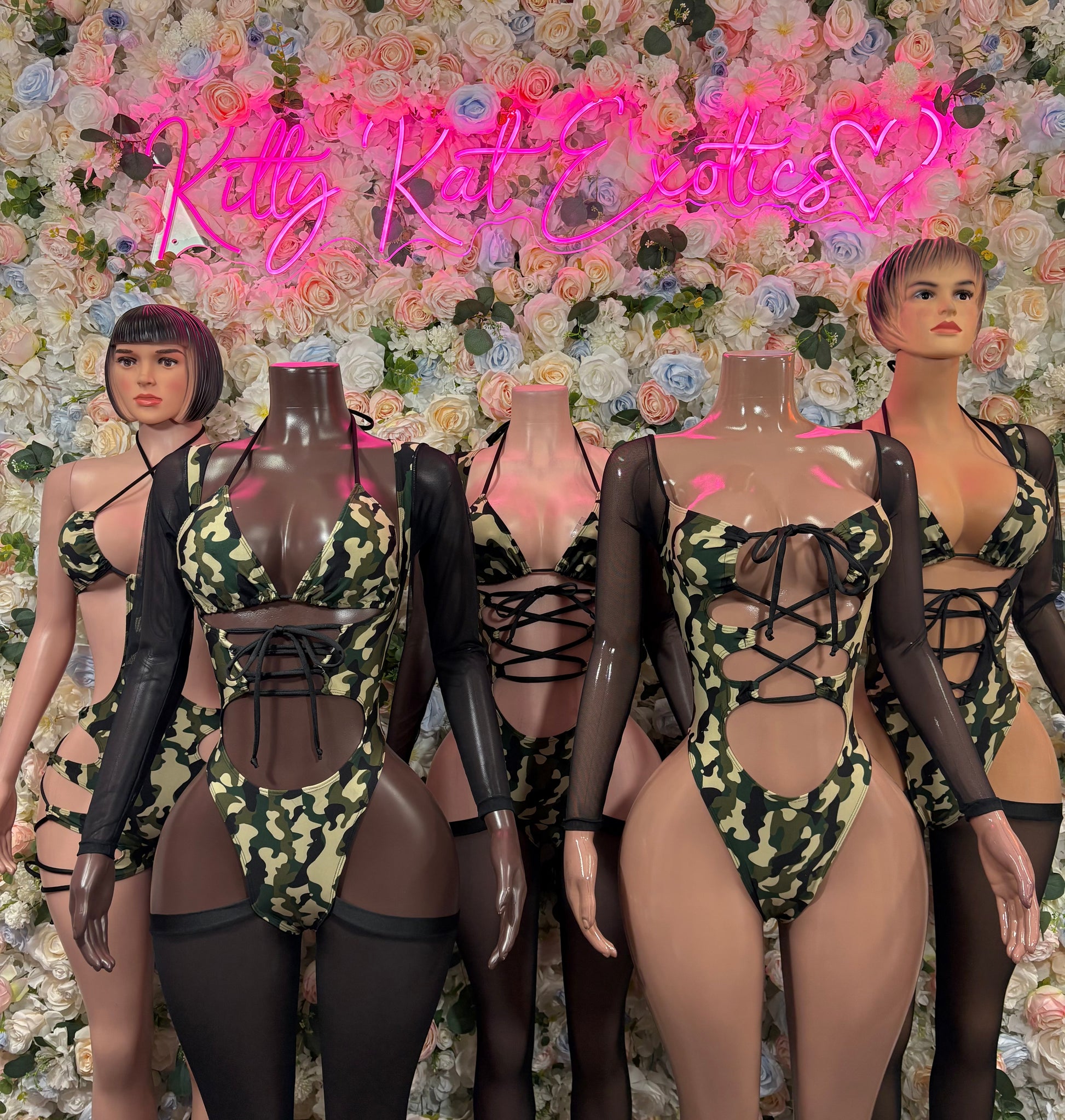 Camo print one-piece bodysuit with black mesh long sleeves, strappy lace-up design