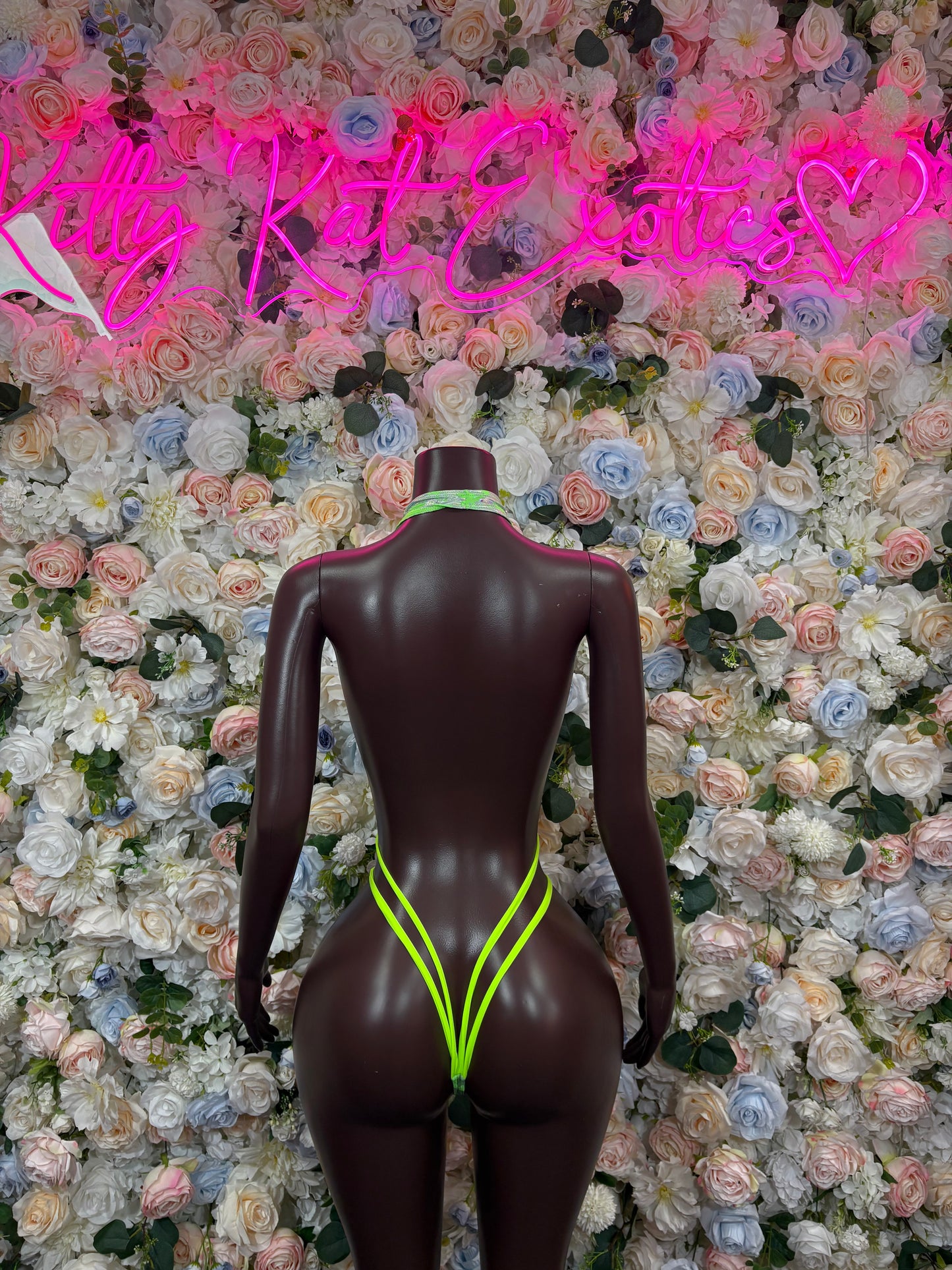 Metallic green open-back rave bodysuit with neon trim and high-cut legs