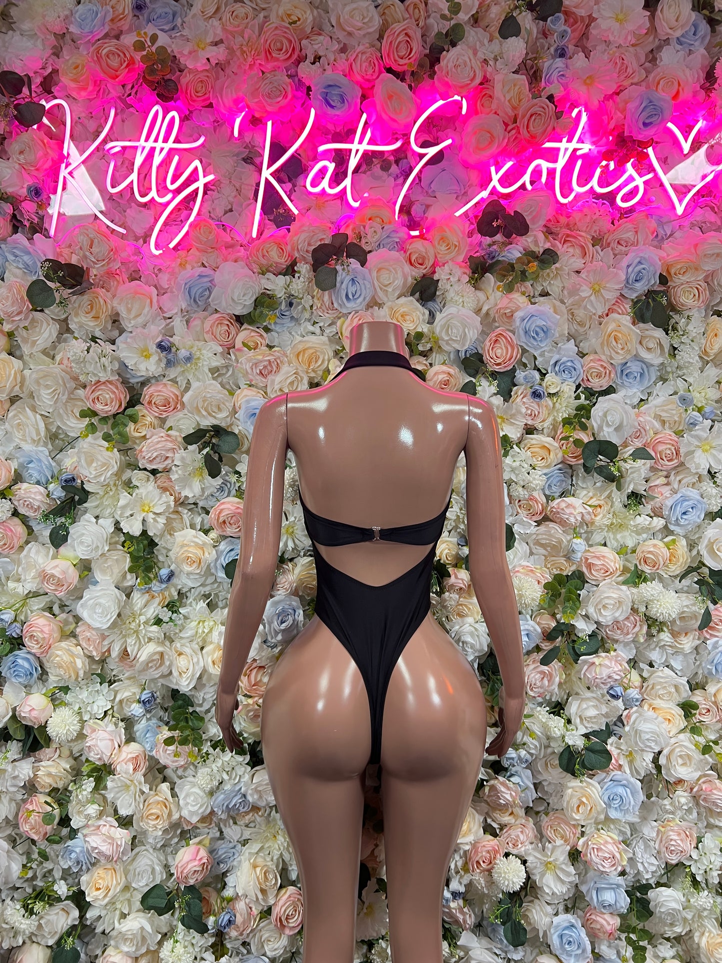 Black one-piece bodysuit with open back and high-cut legs