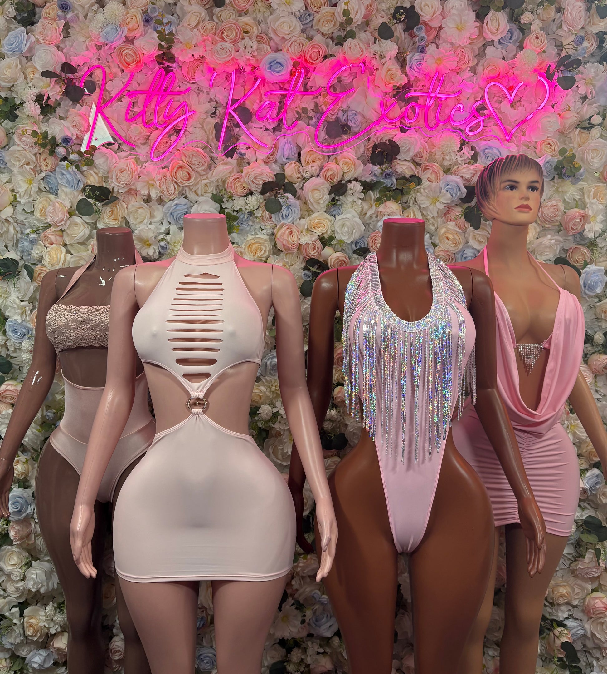 Set of light pink mini dresses with halter cutout fronts on mannequins