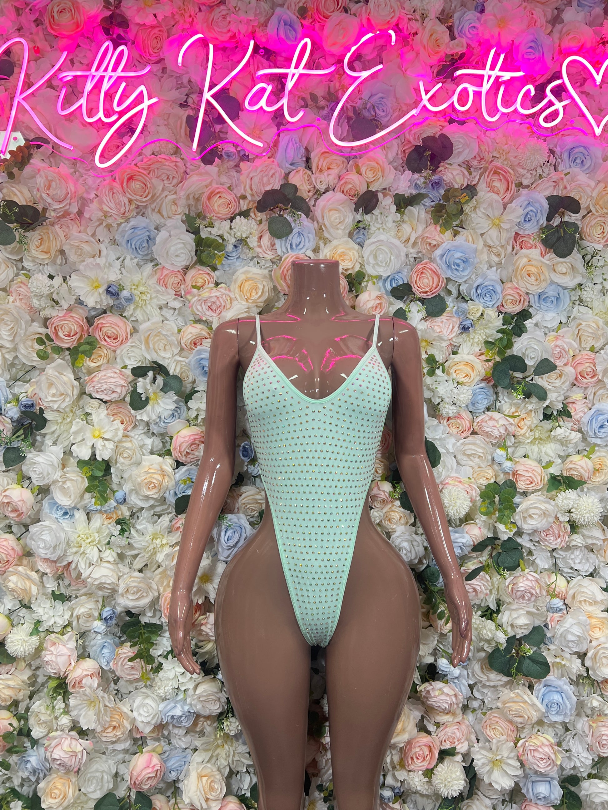 Teal rhinestone one-piece bodysuit with V-neck and thin straps on mannequin