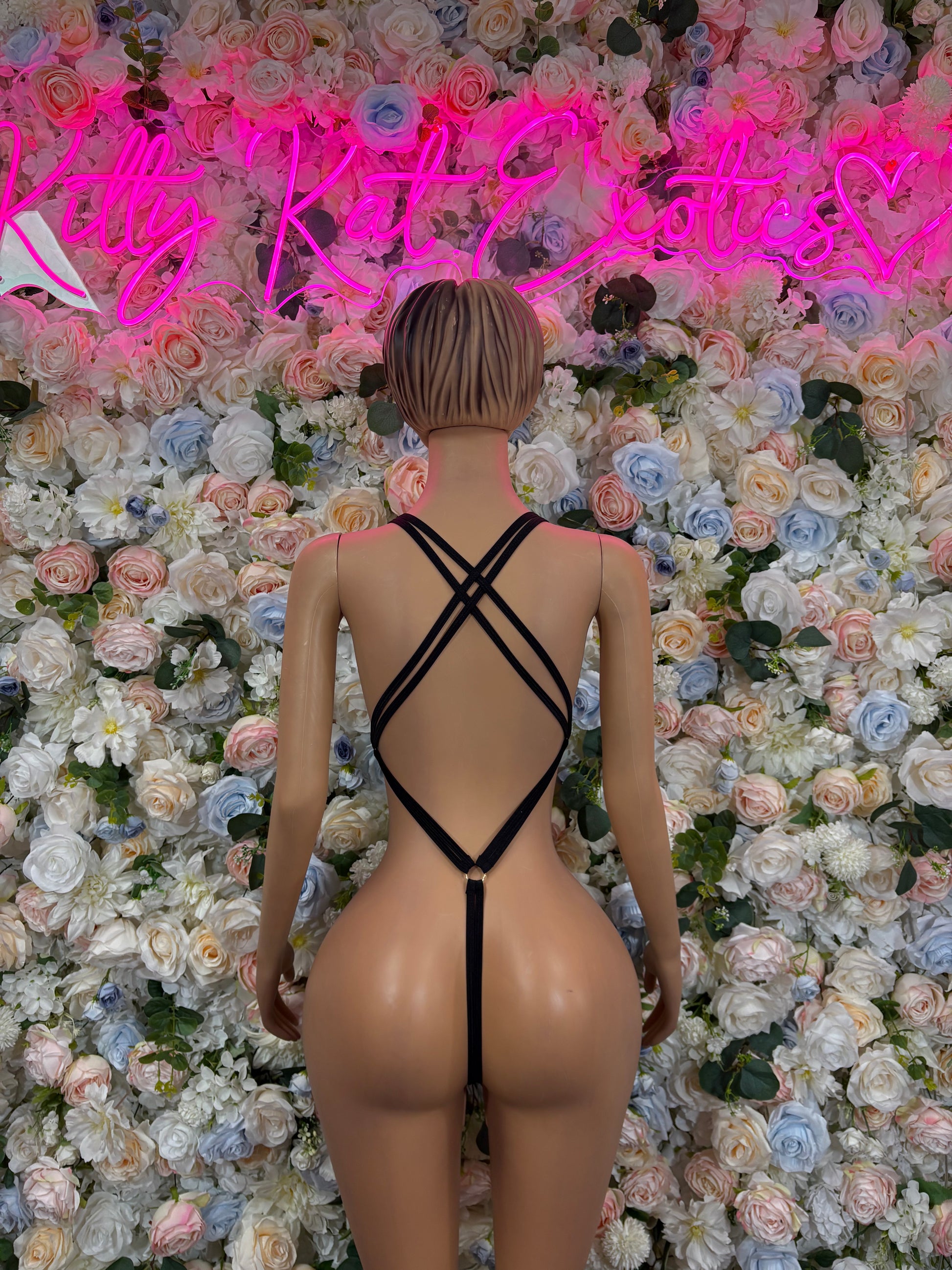 Black rhinestone sleeveless bodysuit with crisscross open-back straps.