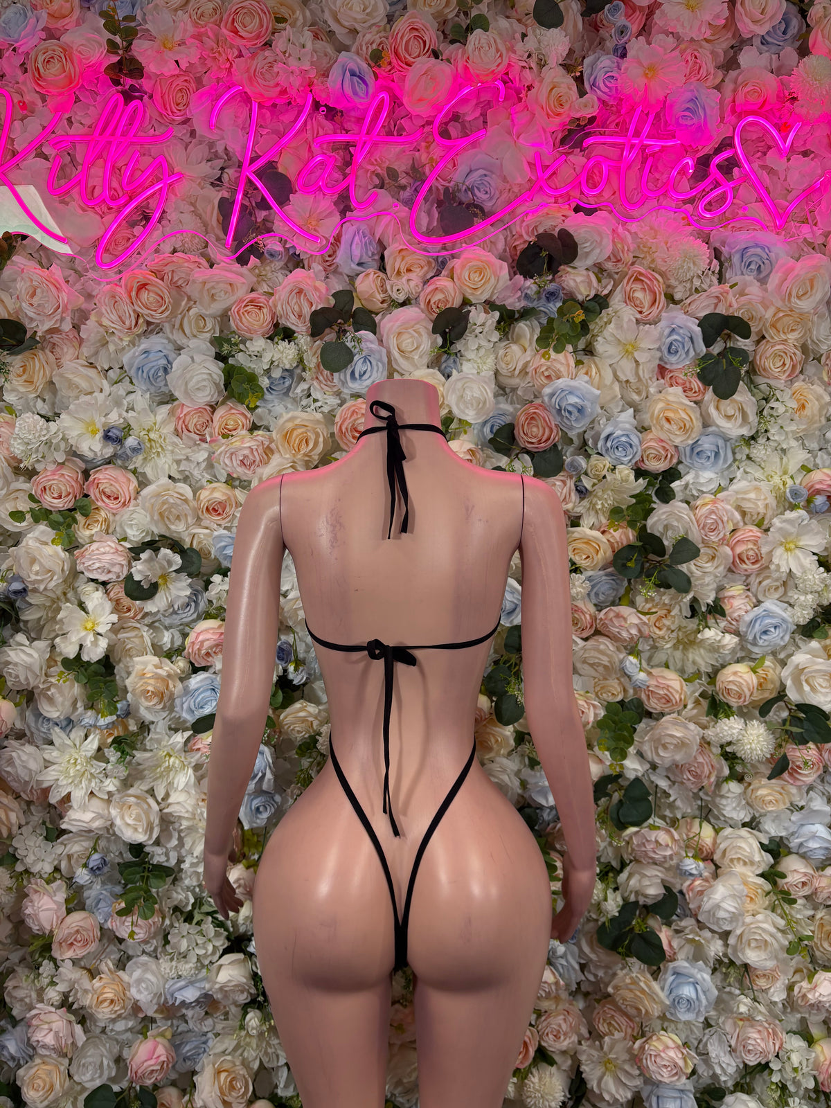 Black slingshot bodysuit with strappy back and rhinestone accents