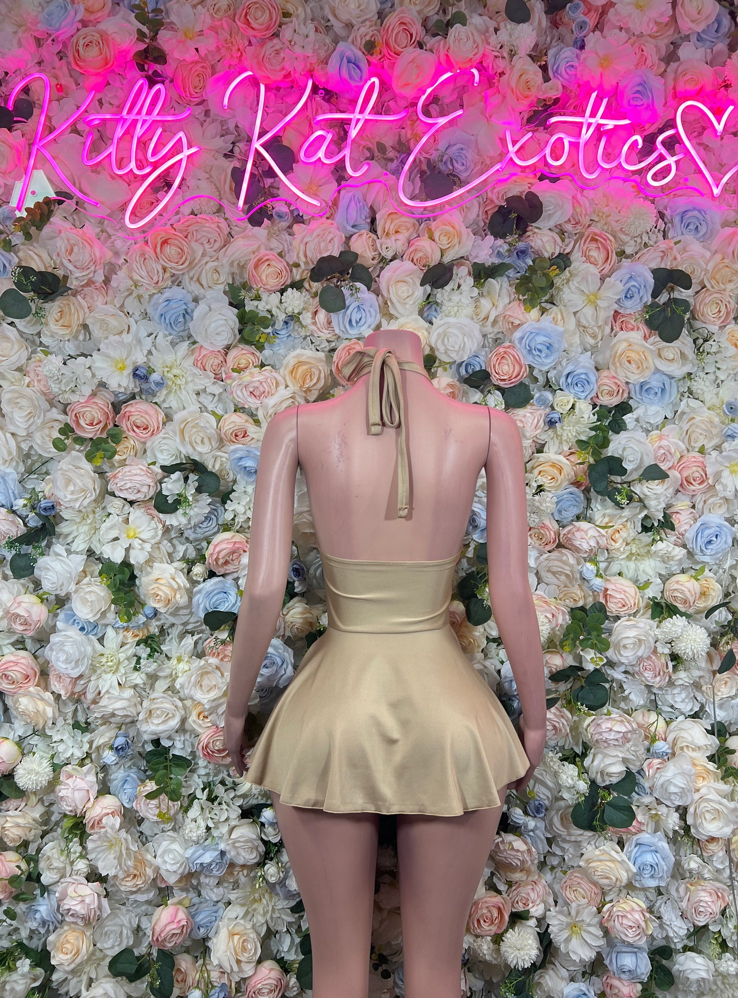 Beige mini dress back view with spaghetti straps and flared peplum hem