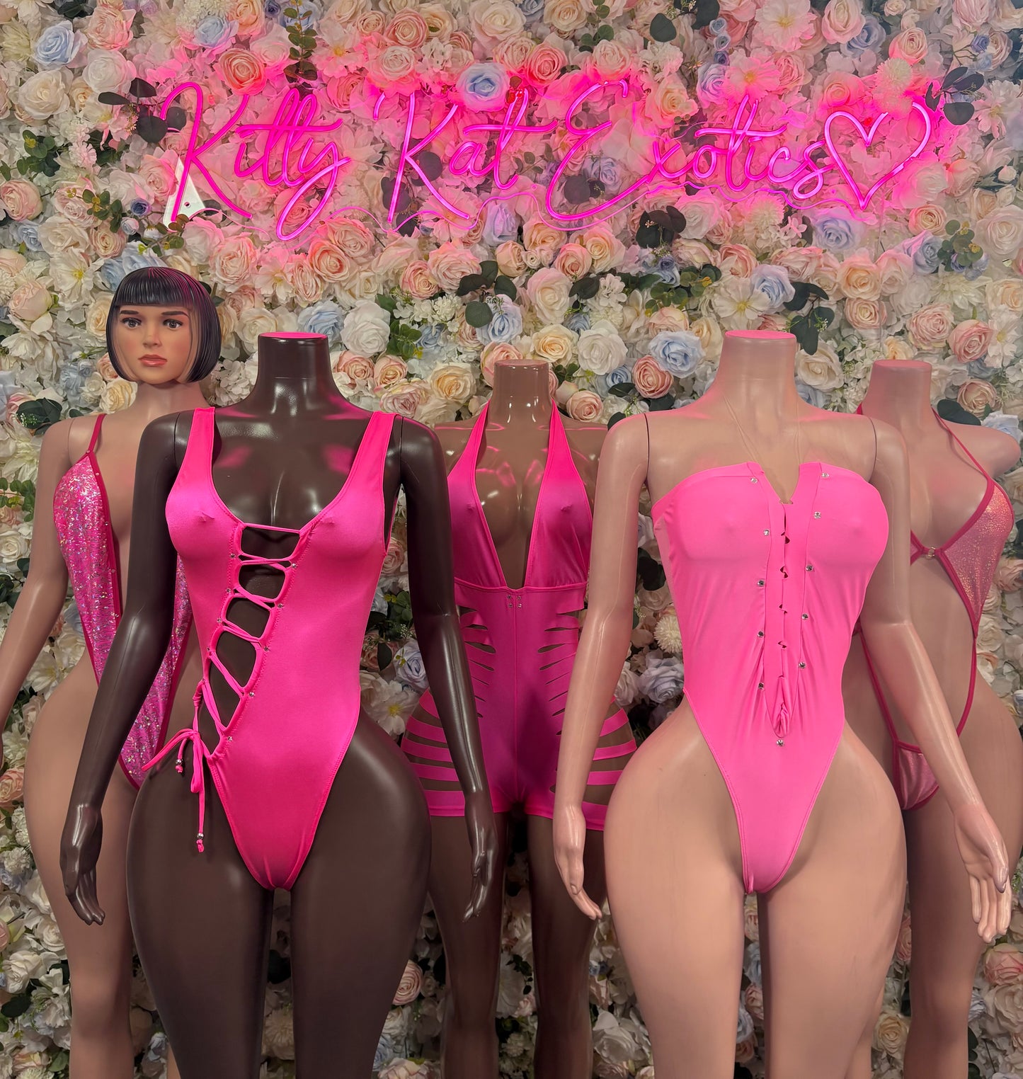 Group of pink festival one-piece bodysuits on mannequins