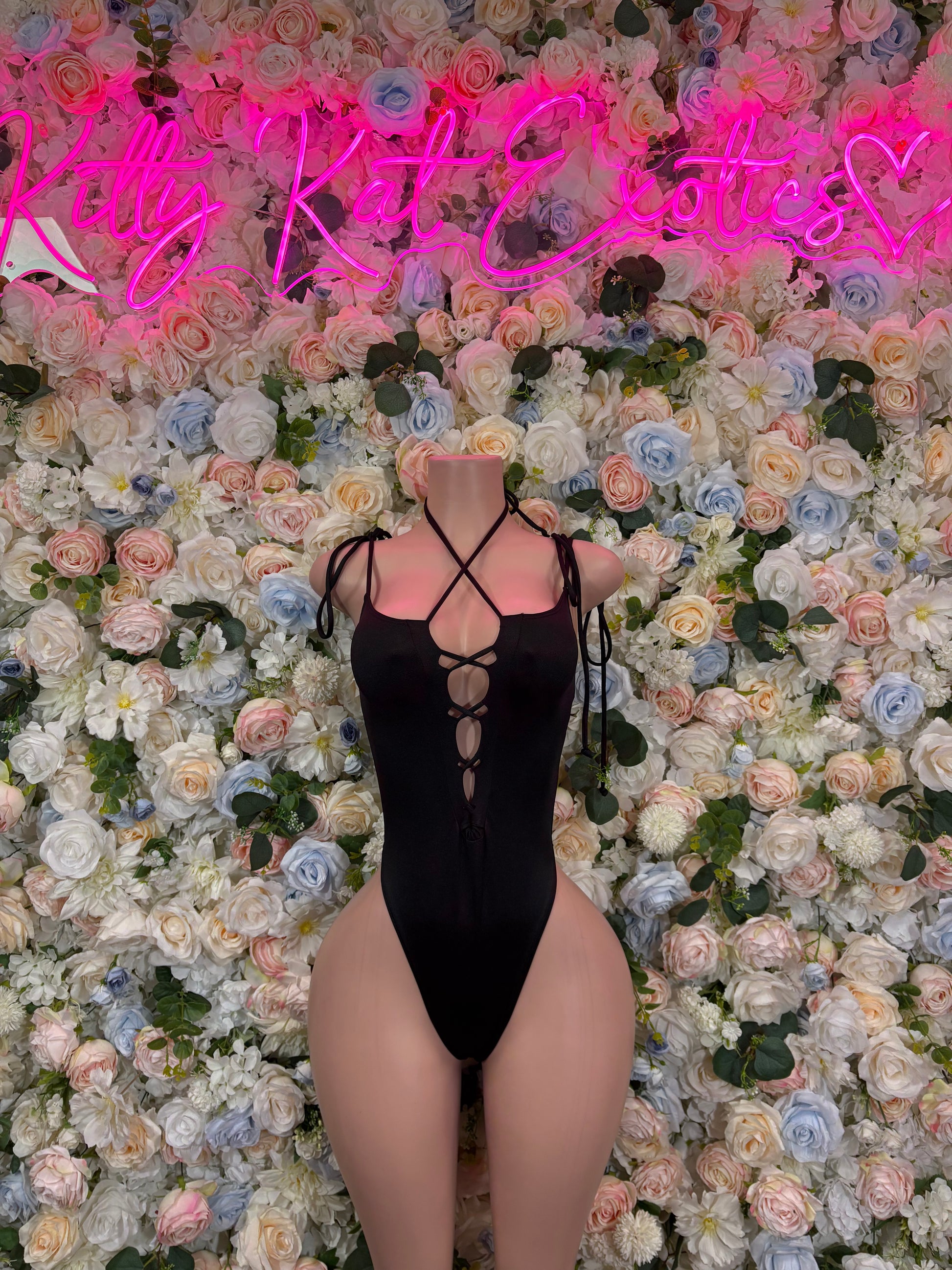 Black strappy one-piece bodysuit with crisscross back and cutout center