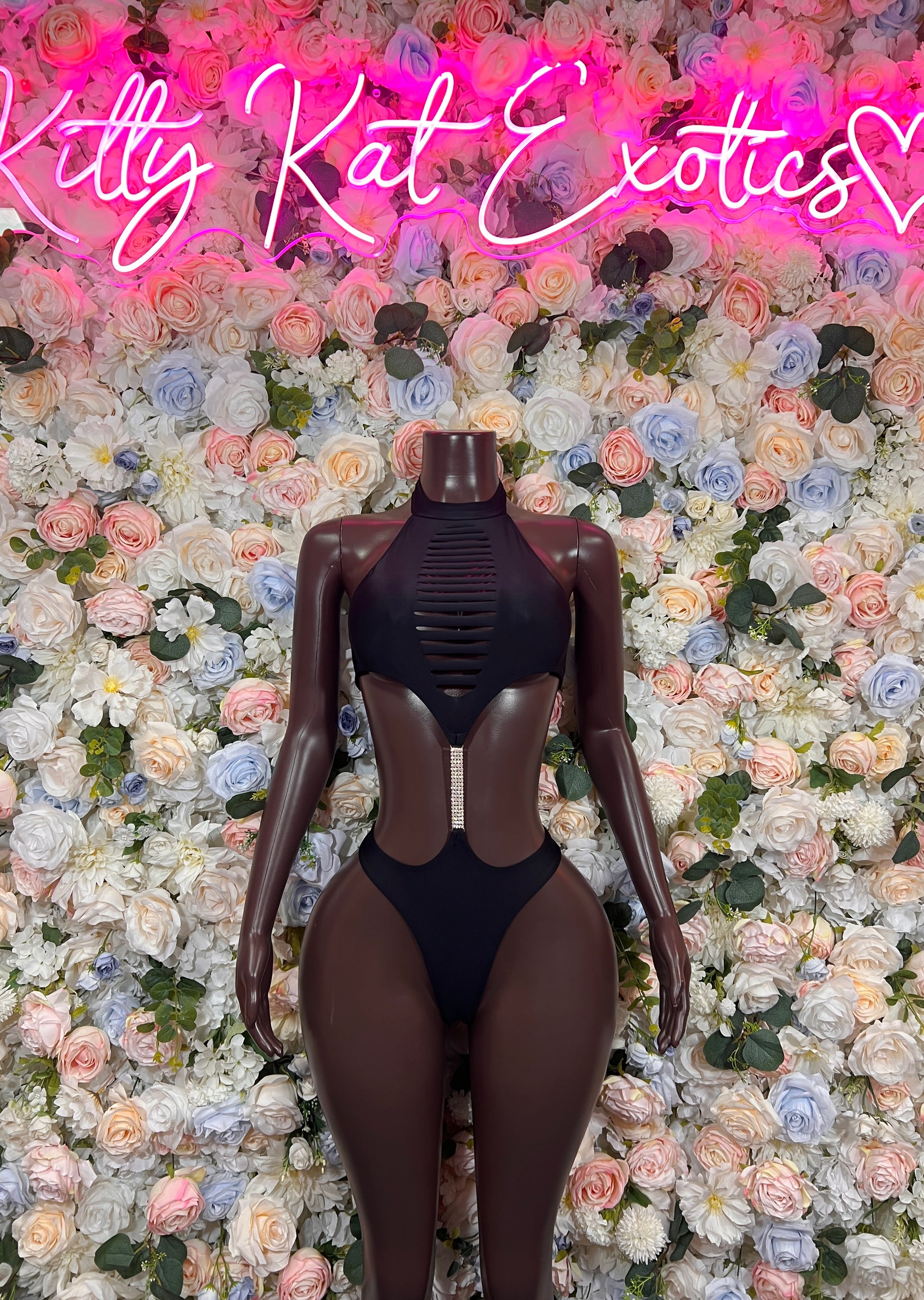 Black one-piece bodysuit with halter neckline and high-cut backless design