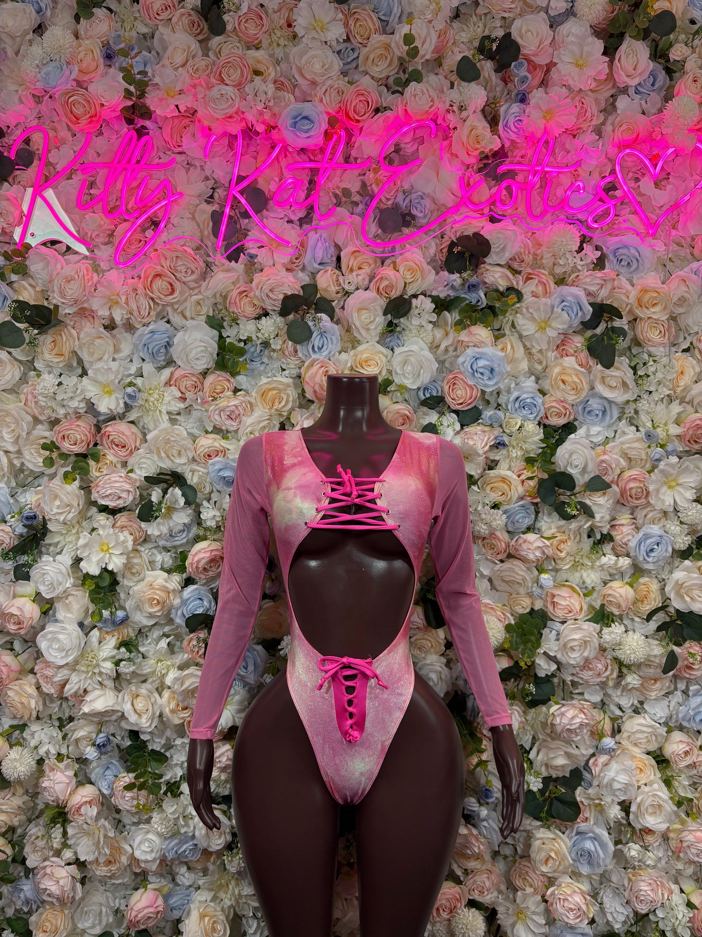 Pink lace-up bodysuit with long sleeves and plunging neckline, sheer bust overlay
