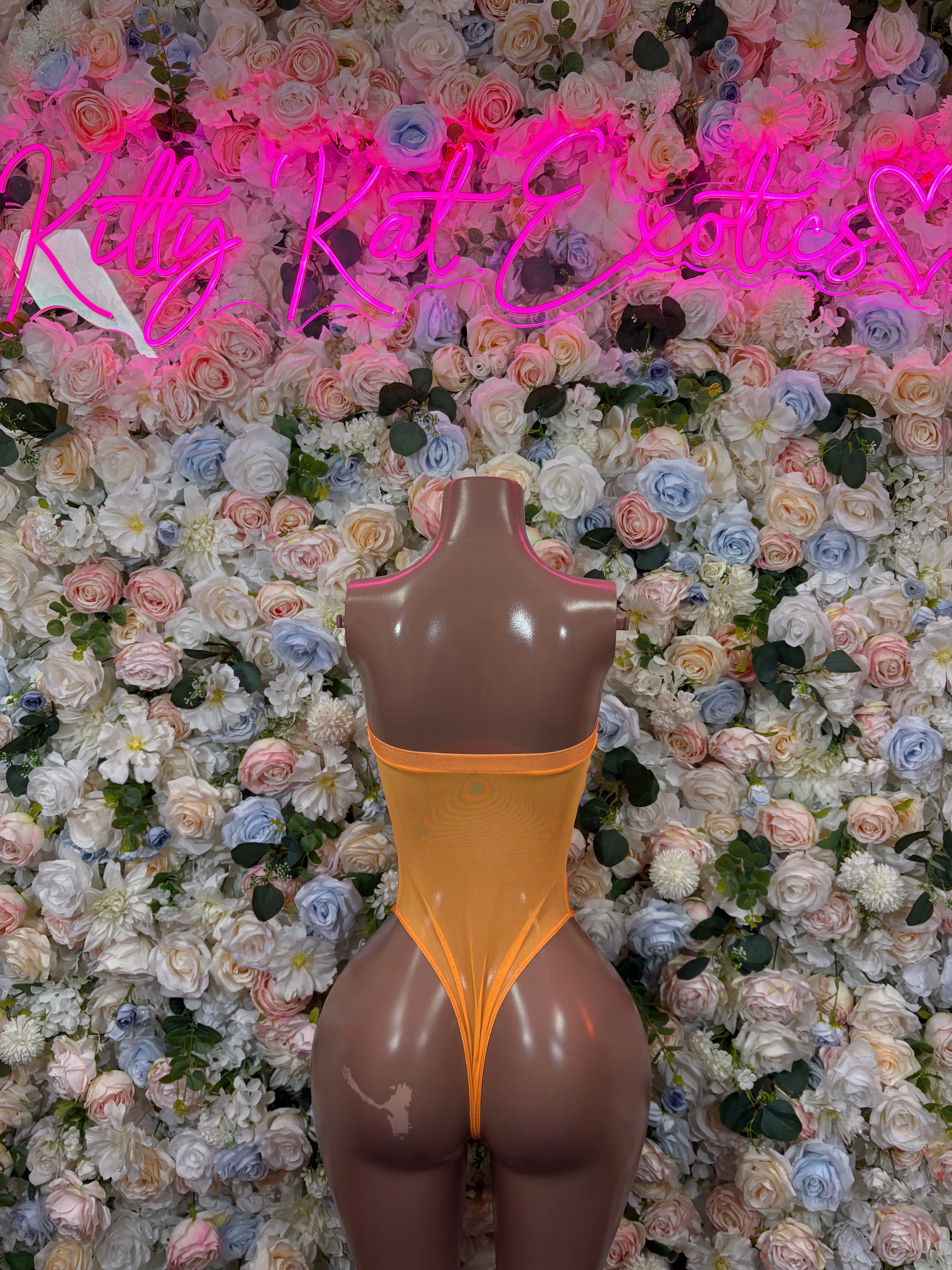 Orange one-piece bodysuit on mannequin with deep V back and high-cut leg