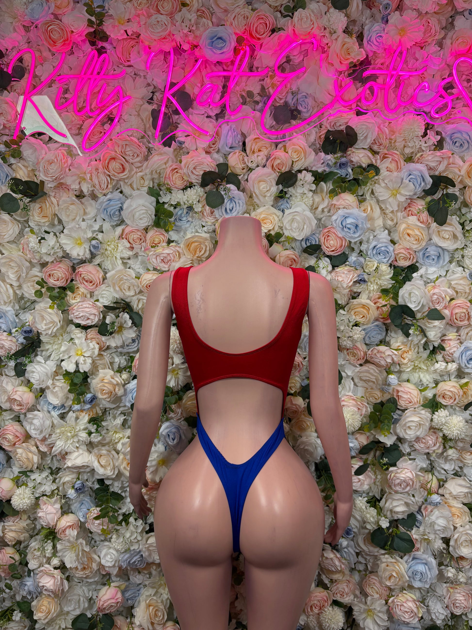 Back of red one-piece swimsuit with blue high-cut bottom and thin straps