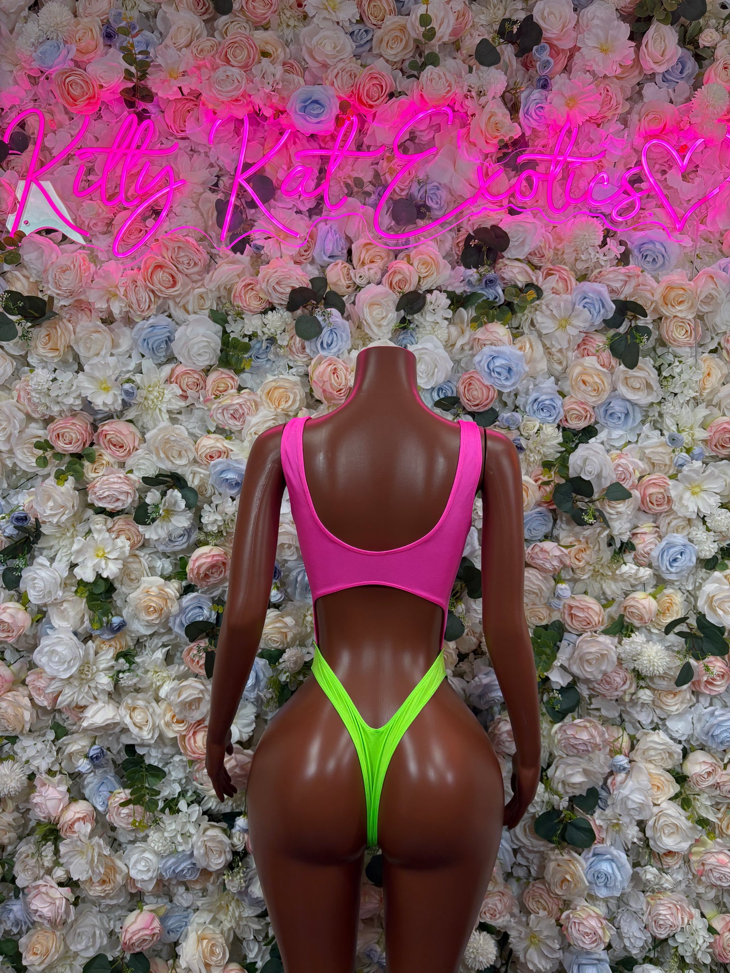 Pink and neon green sleeveless bodysuit, high-cut legs and open back