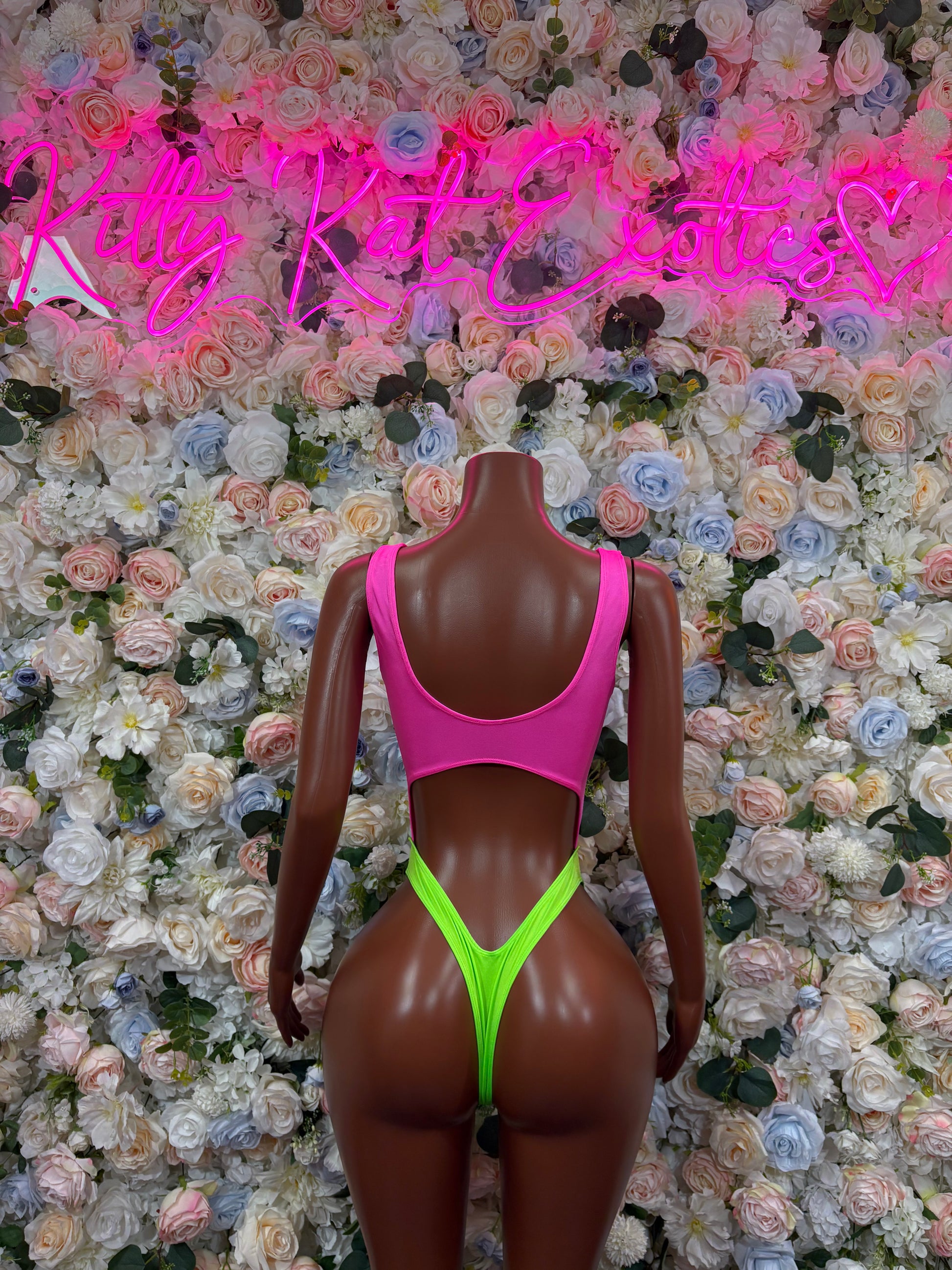 Pink and neon green sleeveless bodysuit, high-cut legs and open back