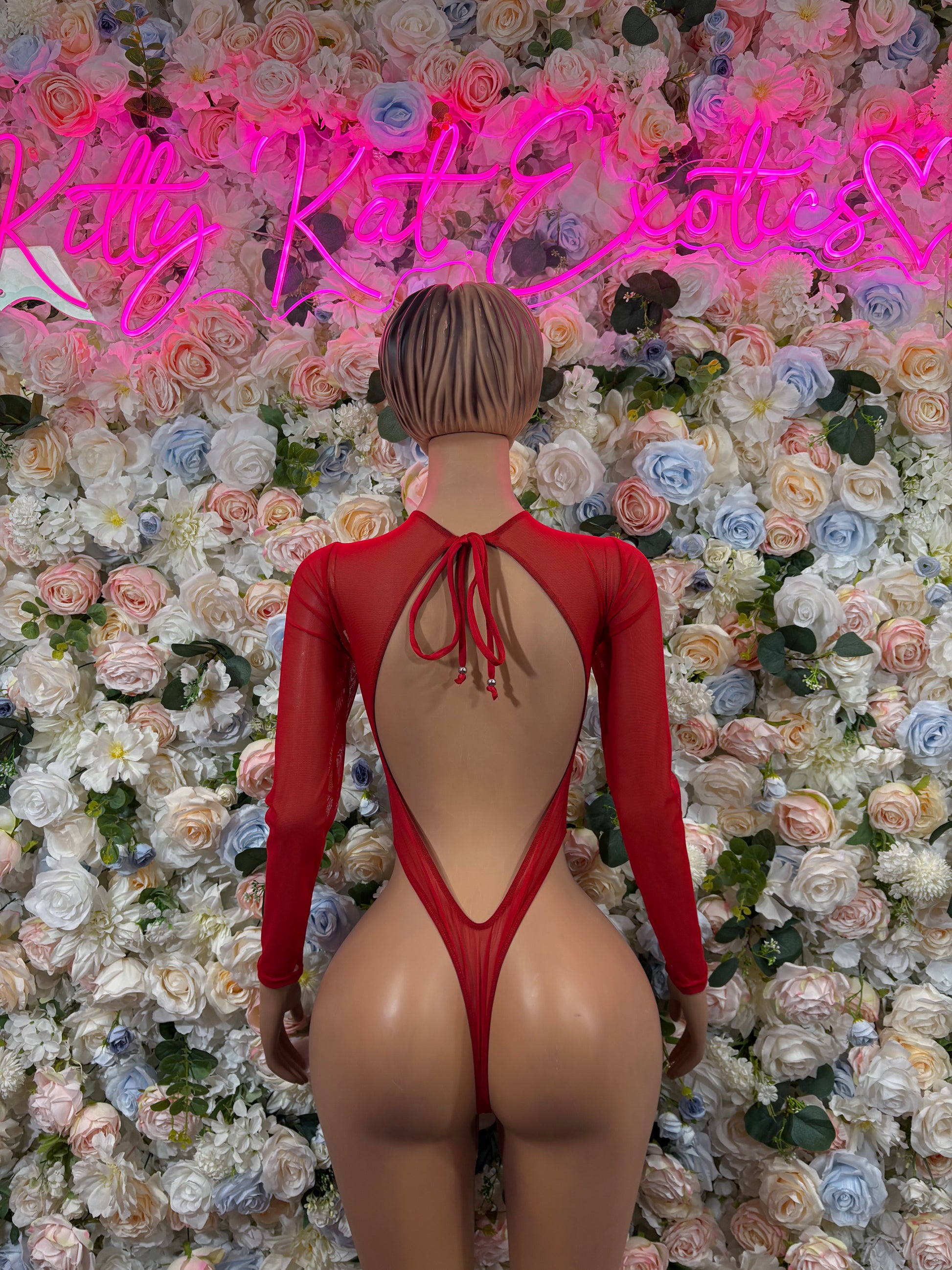 Red backless bodysuit with crisscross strap detail and high-leg coverage