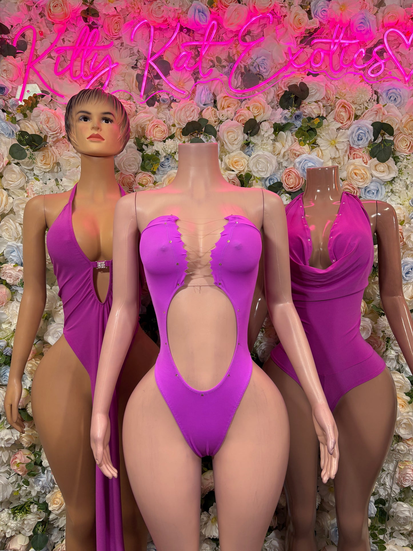 Purple one-piece rave bodysuit with deep V neckline and backless open-back design