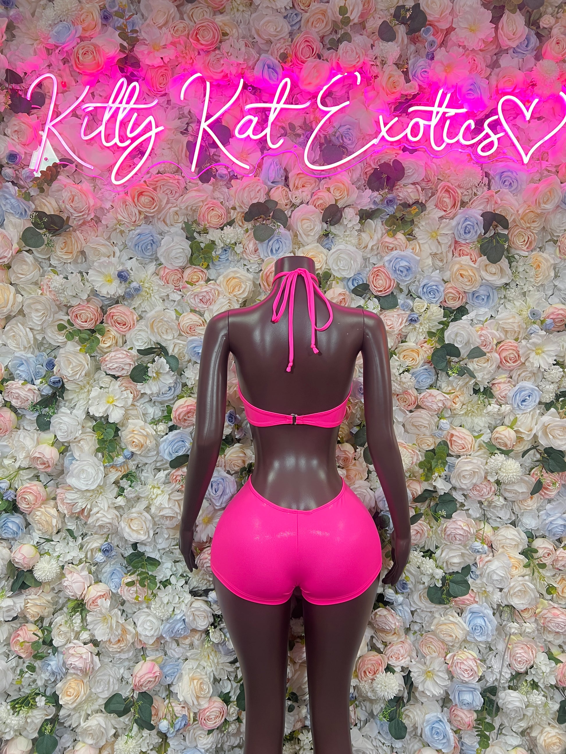 Hot pink metallic halter two-piece with bow-tie neck and high-rise shorts