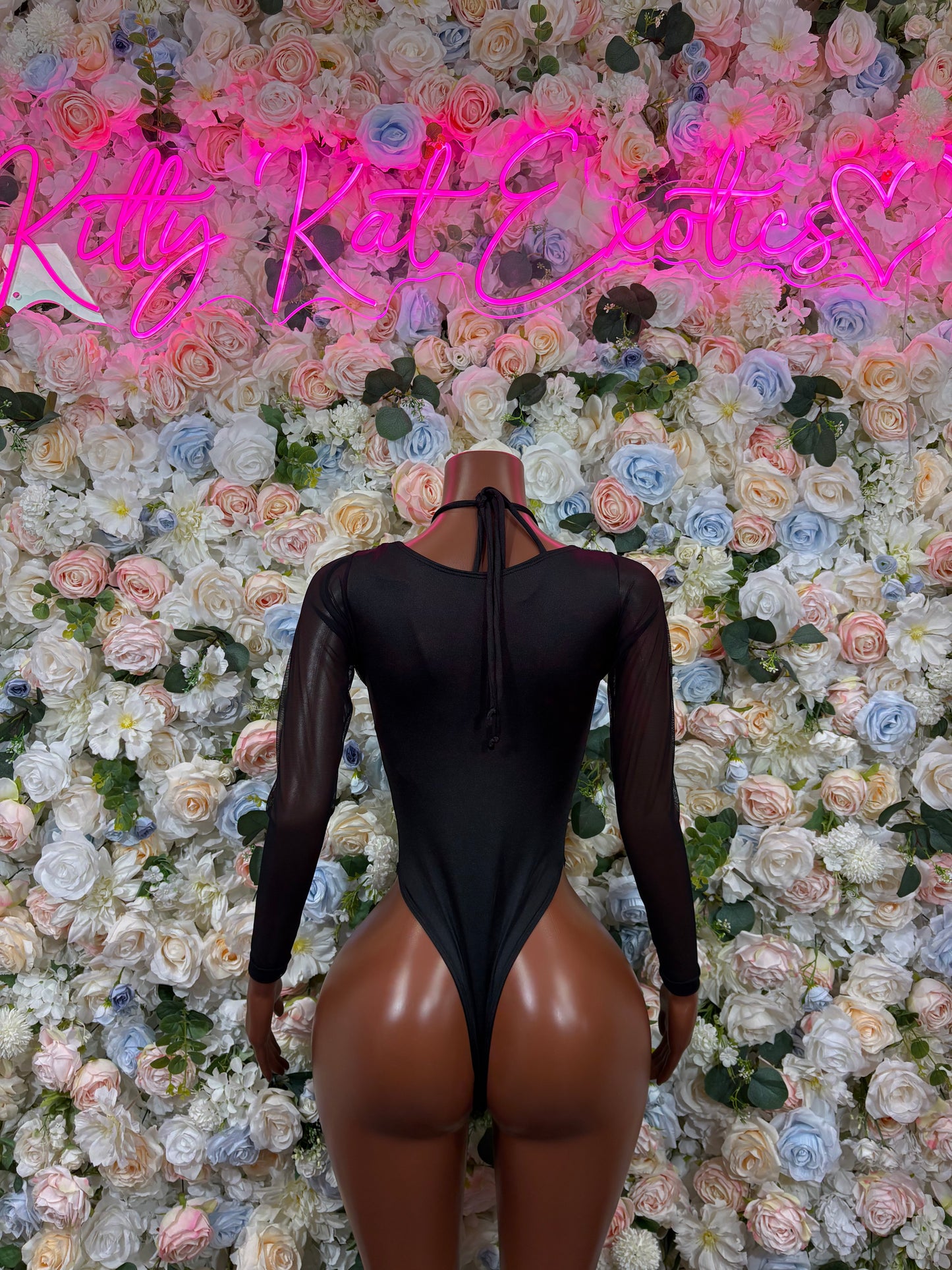 Black one-piece bodysuit with sheer long sleeves and open back