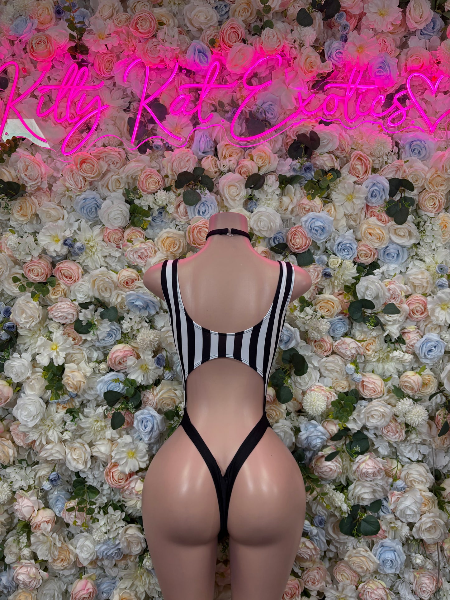Back view of striped one-piece bodysuit with open back and black binding