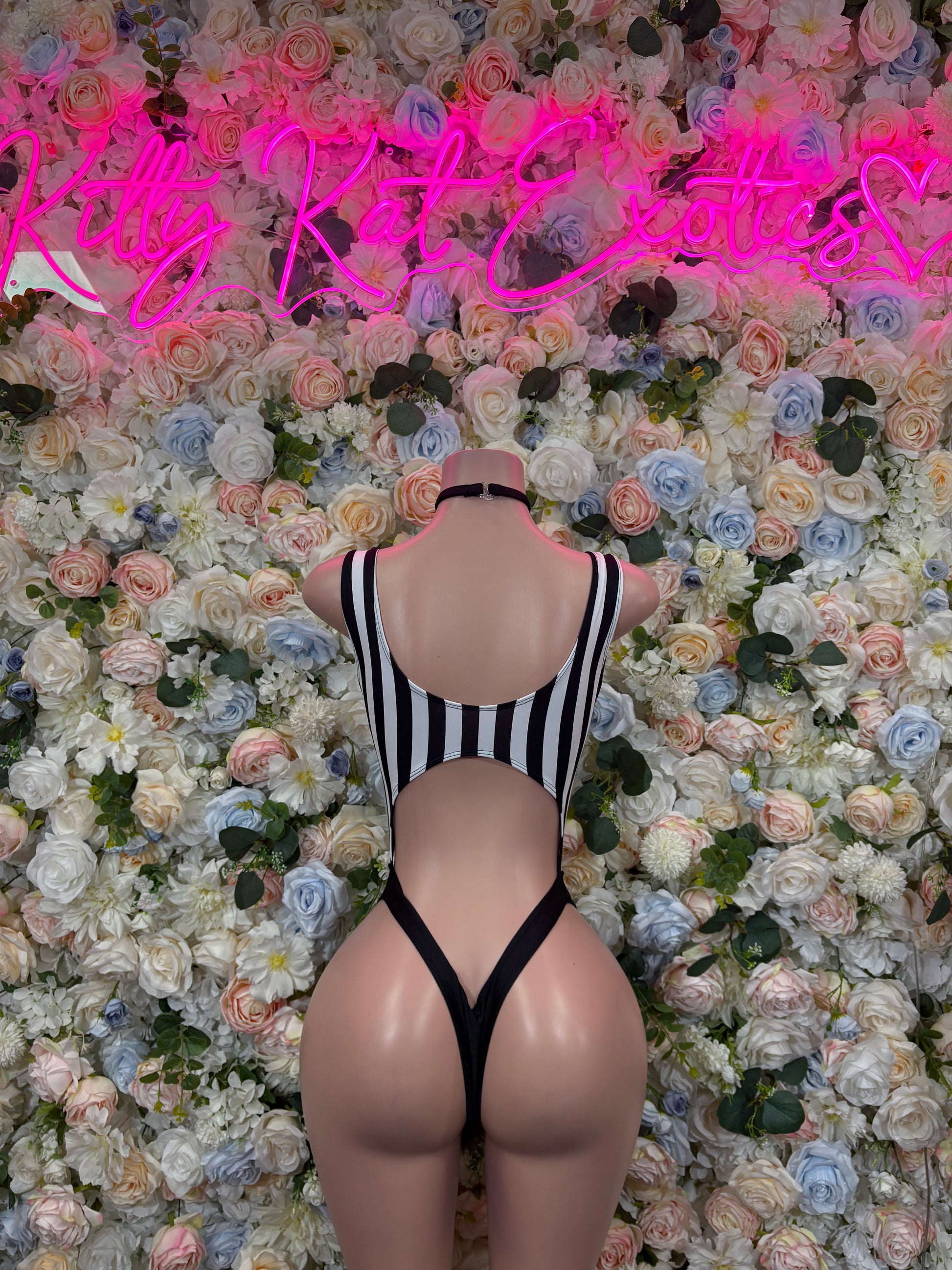 Back view of striped one-piece bodysuit with open back and black binding