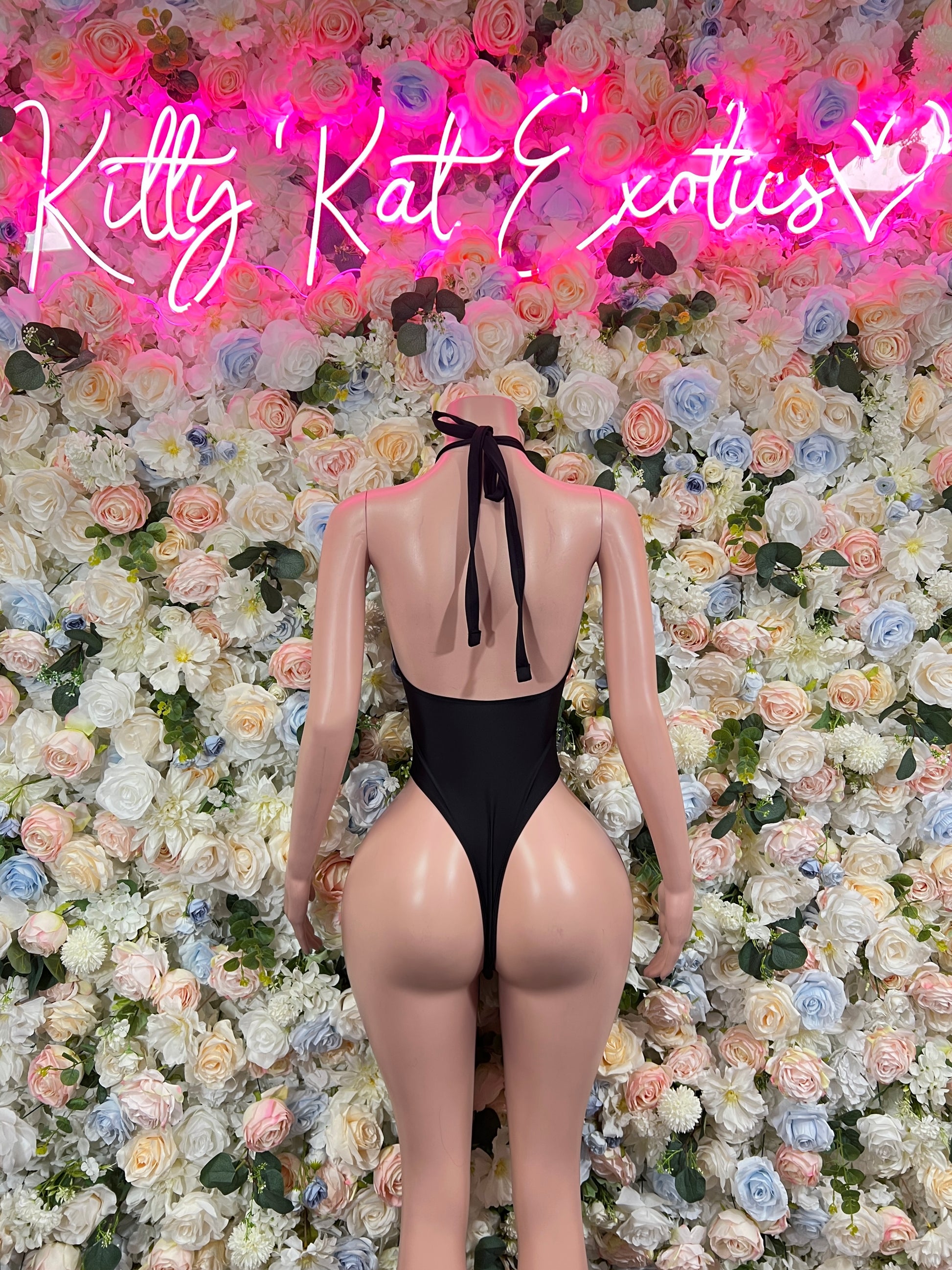 Black one-piece bodysuit with open back tie straps and V back cut