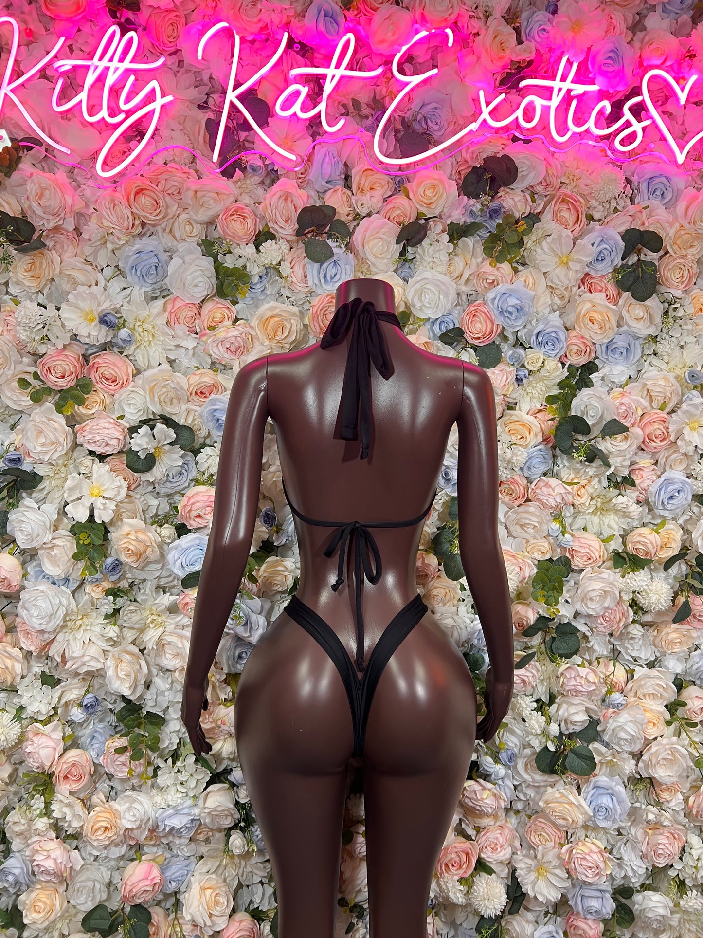 Black one-piece bodysuit with open back and neck tie, back view
