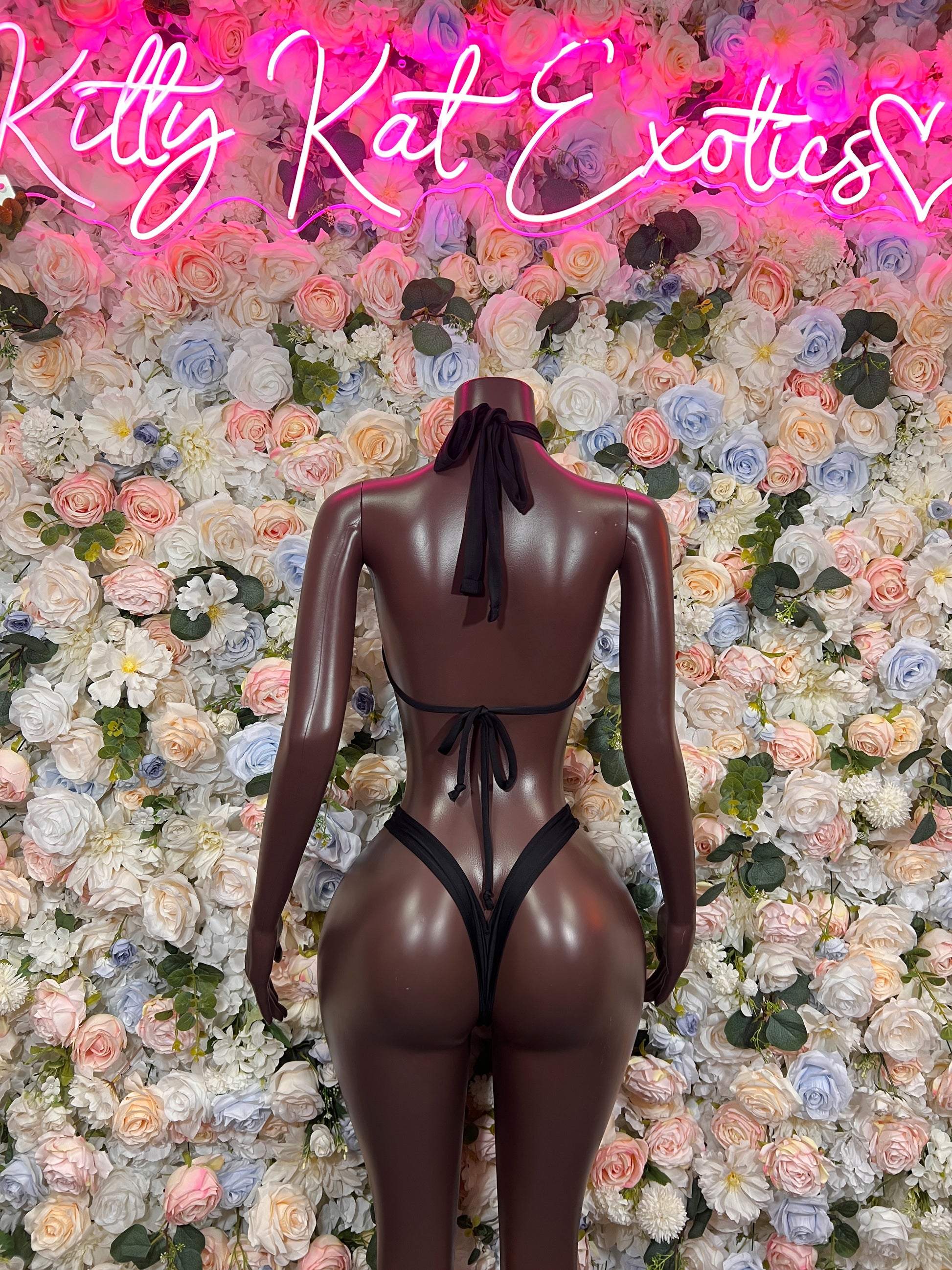 Black one-piece bodysuit with open back and neck tie, back view