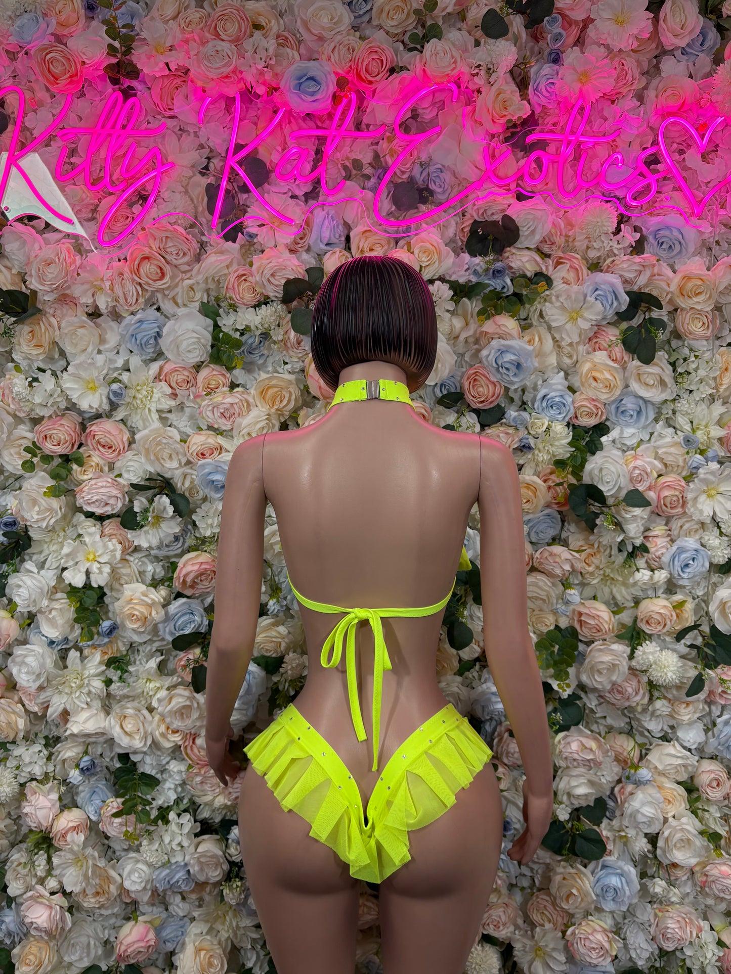 Neon green two-piece ravewear set with halter back tie and ruffle briefs, back view