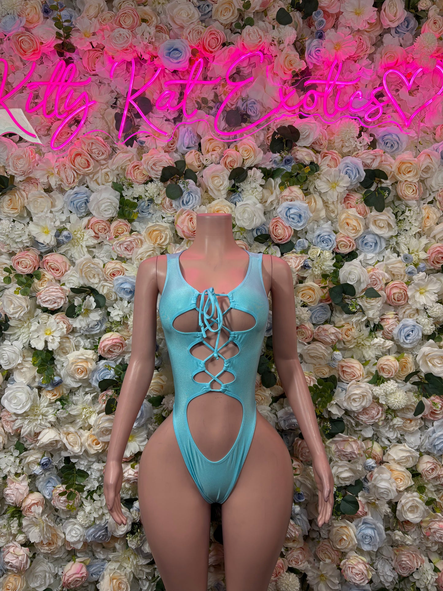 Teal lace-up bodysuit with crisscross chest cutouts and high-leg coverage