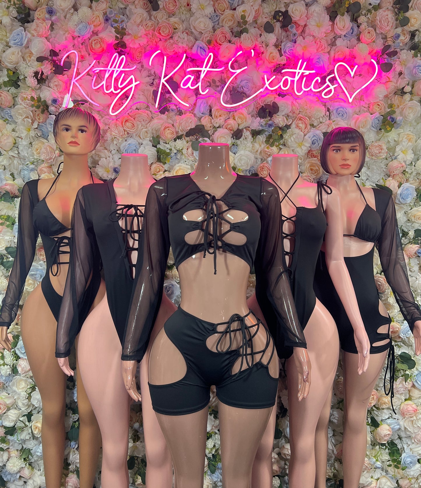 Black lace-up bodysuit with sheer long sleeves and front cutout; short bottoms