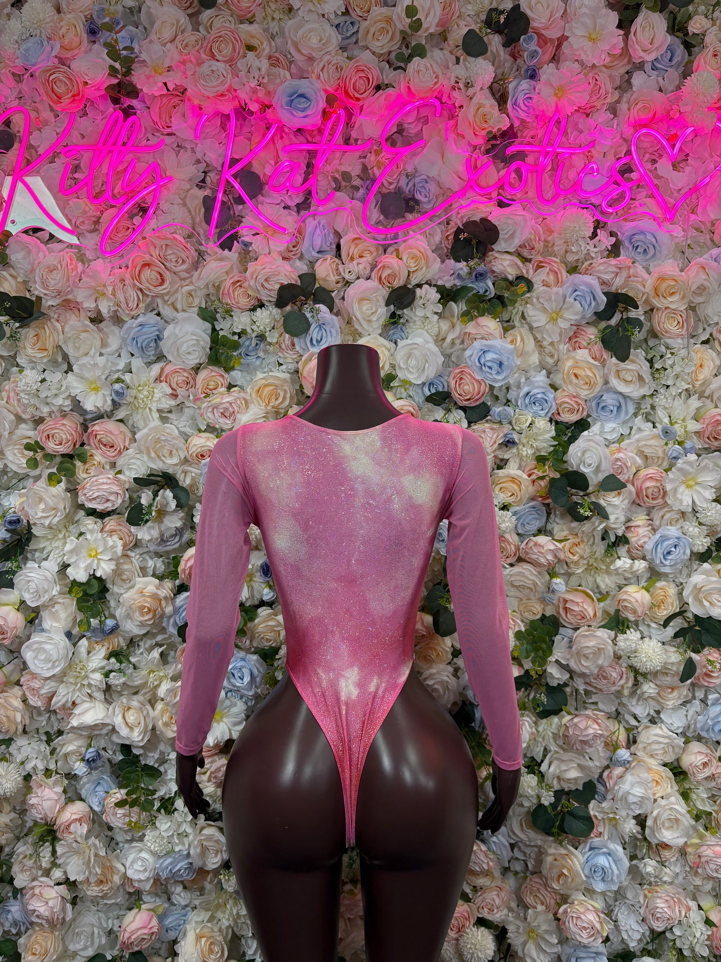 Pink long-sleeve bodysuit with lace-up front and low V neckline, thong cut