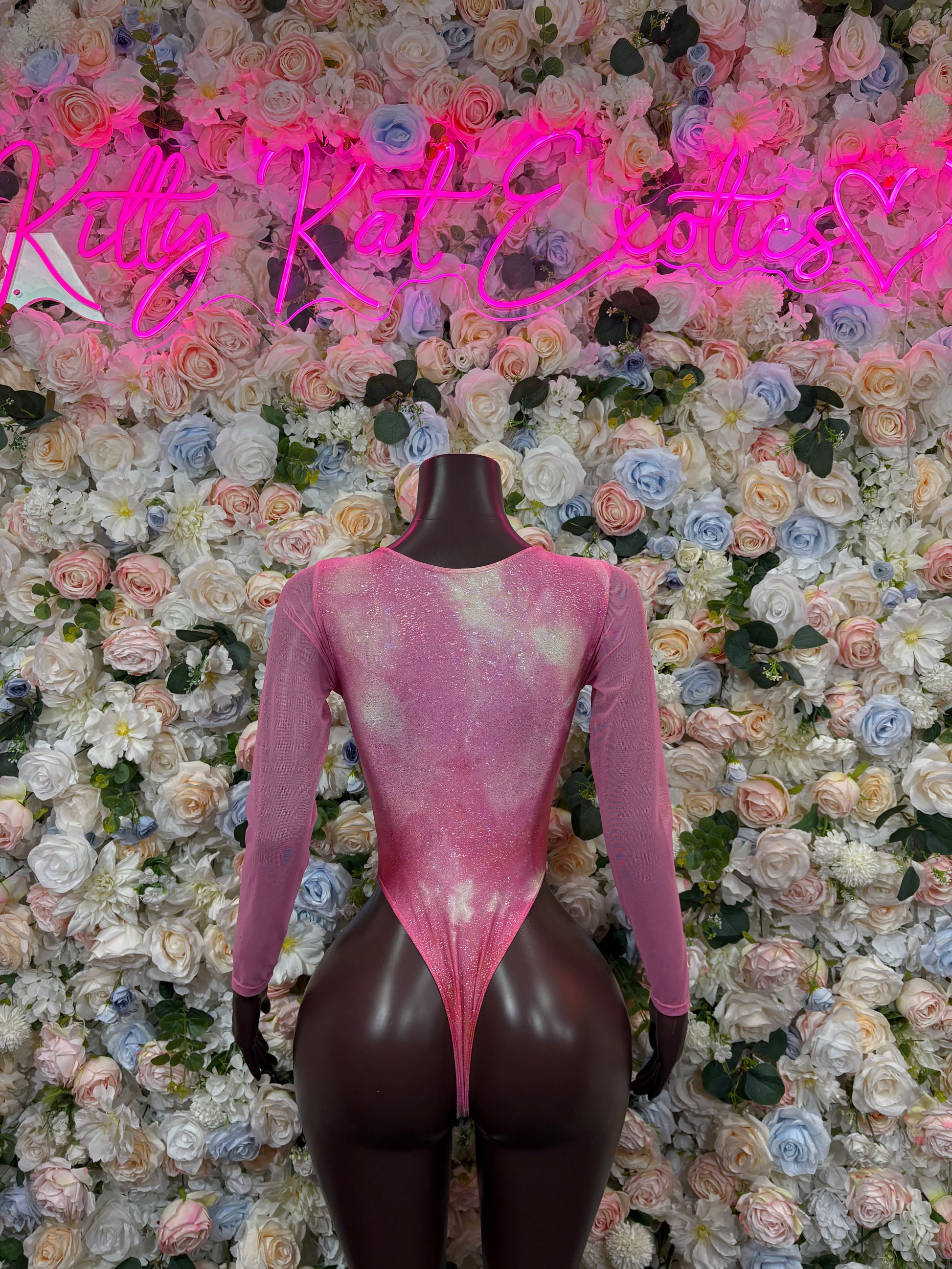 Pink long-sleeve bodysuit with lace-up front and low V neckline, thong cut