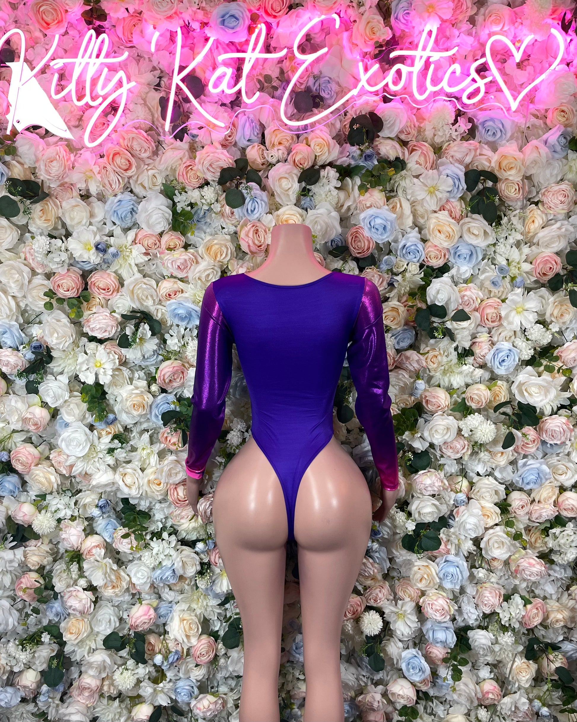 Purple long-sleeve thong bodysuit with deep V neckline and center lace-up