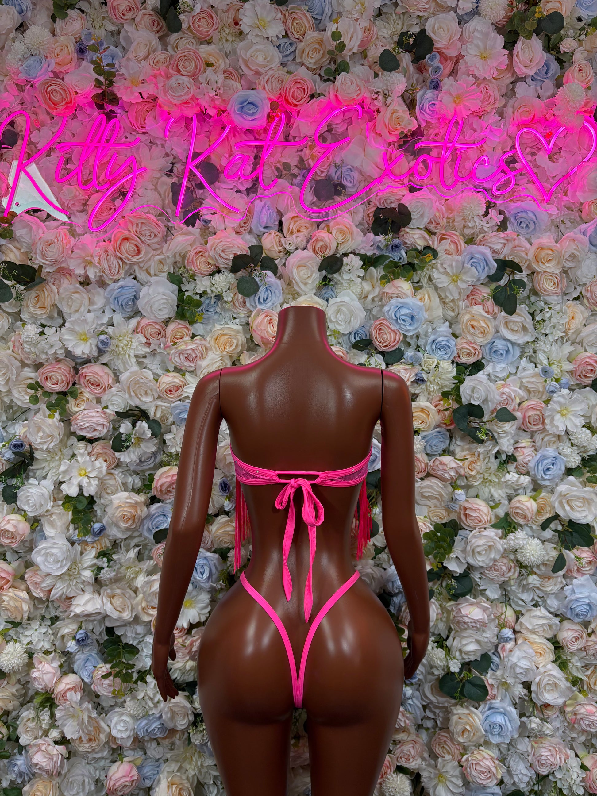 Hot pink backless one-piece bodysuit with V-shaped back straps and bow ties