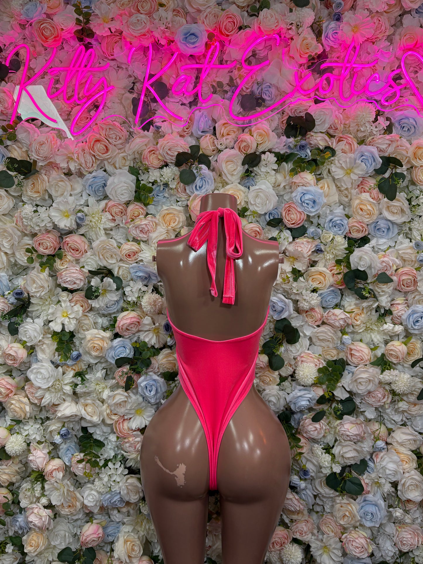 Pink halter one-piece bodysuit with tied back and high-cut leg
